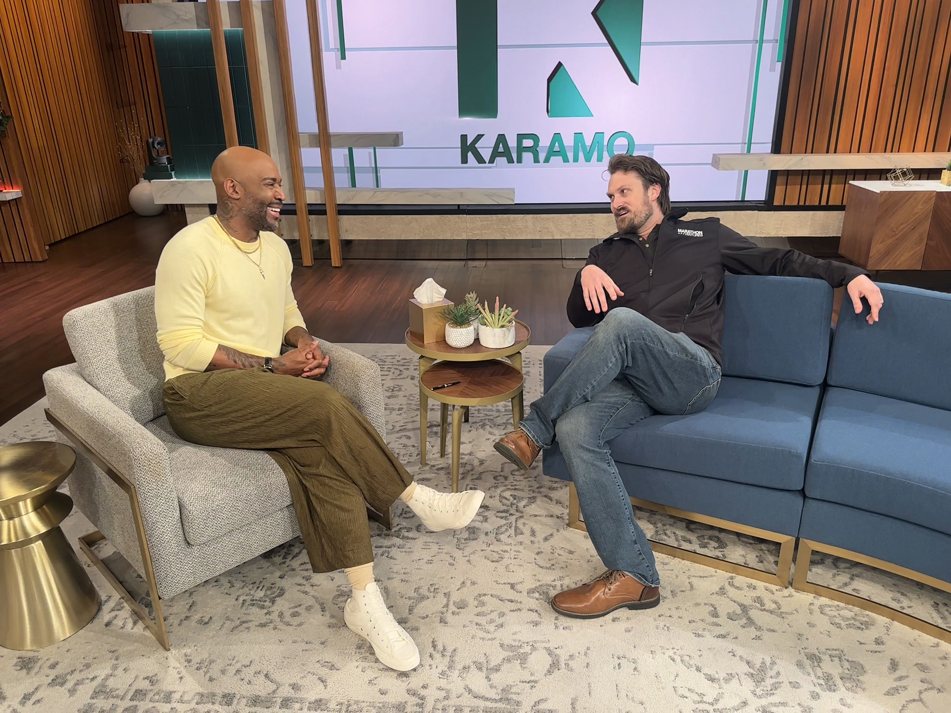 Tyler Blodgett and Karamo Brown laughing together on the Karamo talk show set