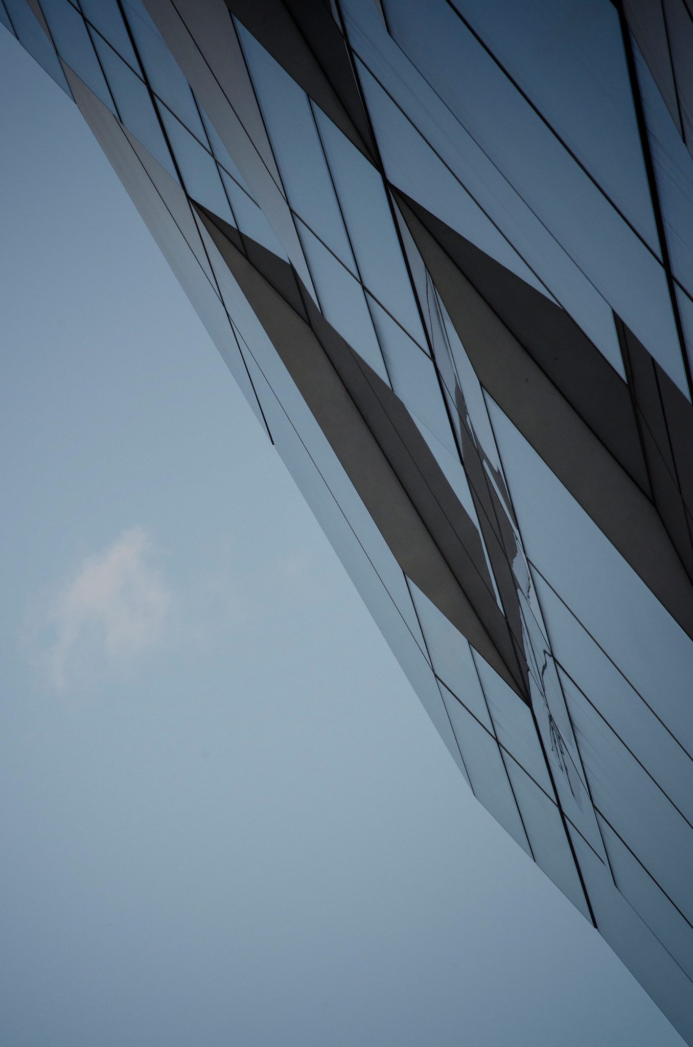 Straight up, a tower's glass panels slice into the sky.