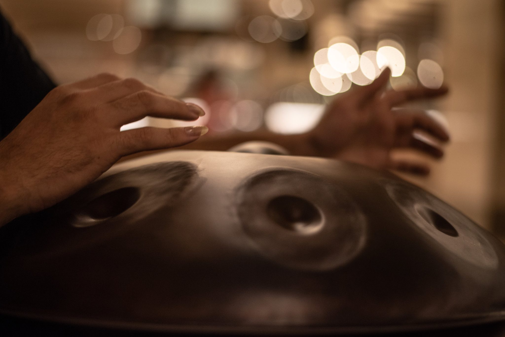 The Hang, a class of steel drum known as a hand pan, is played by gently striking the grooved areas with fingers. Each section is precisely tuned to produce a specific note.
