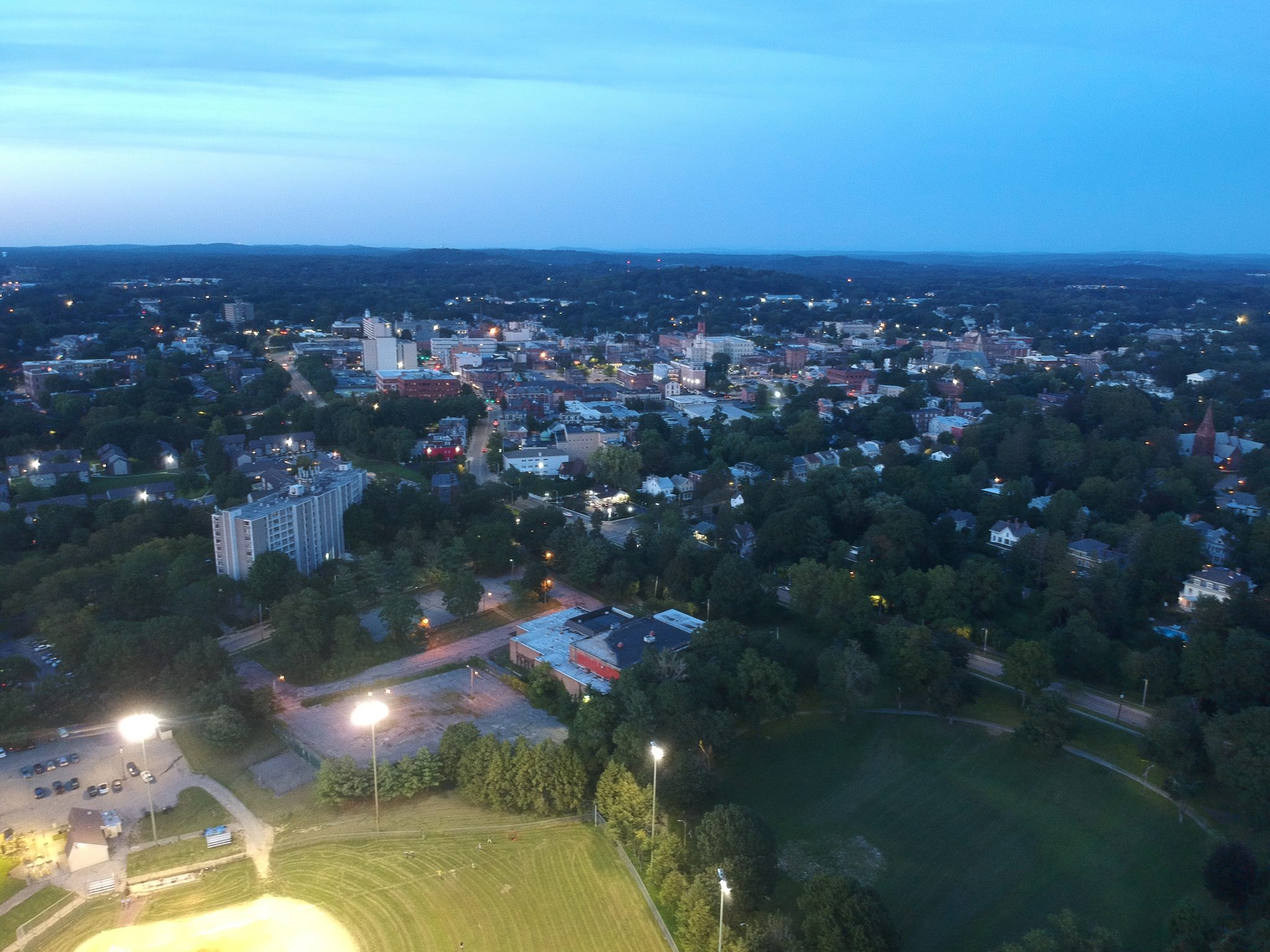 Dusk settles over the city as the ballfield lights come on.