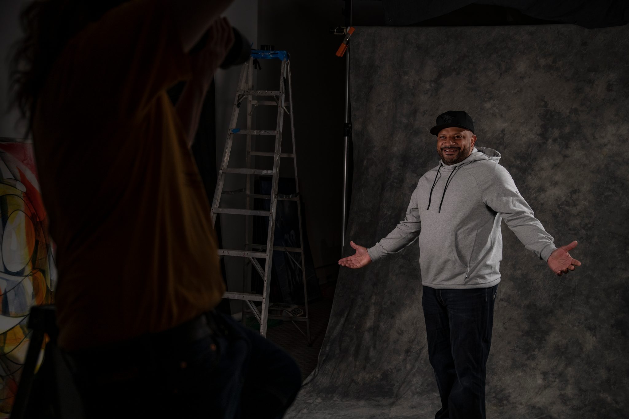 Arms open under the studio lights.