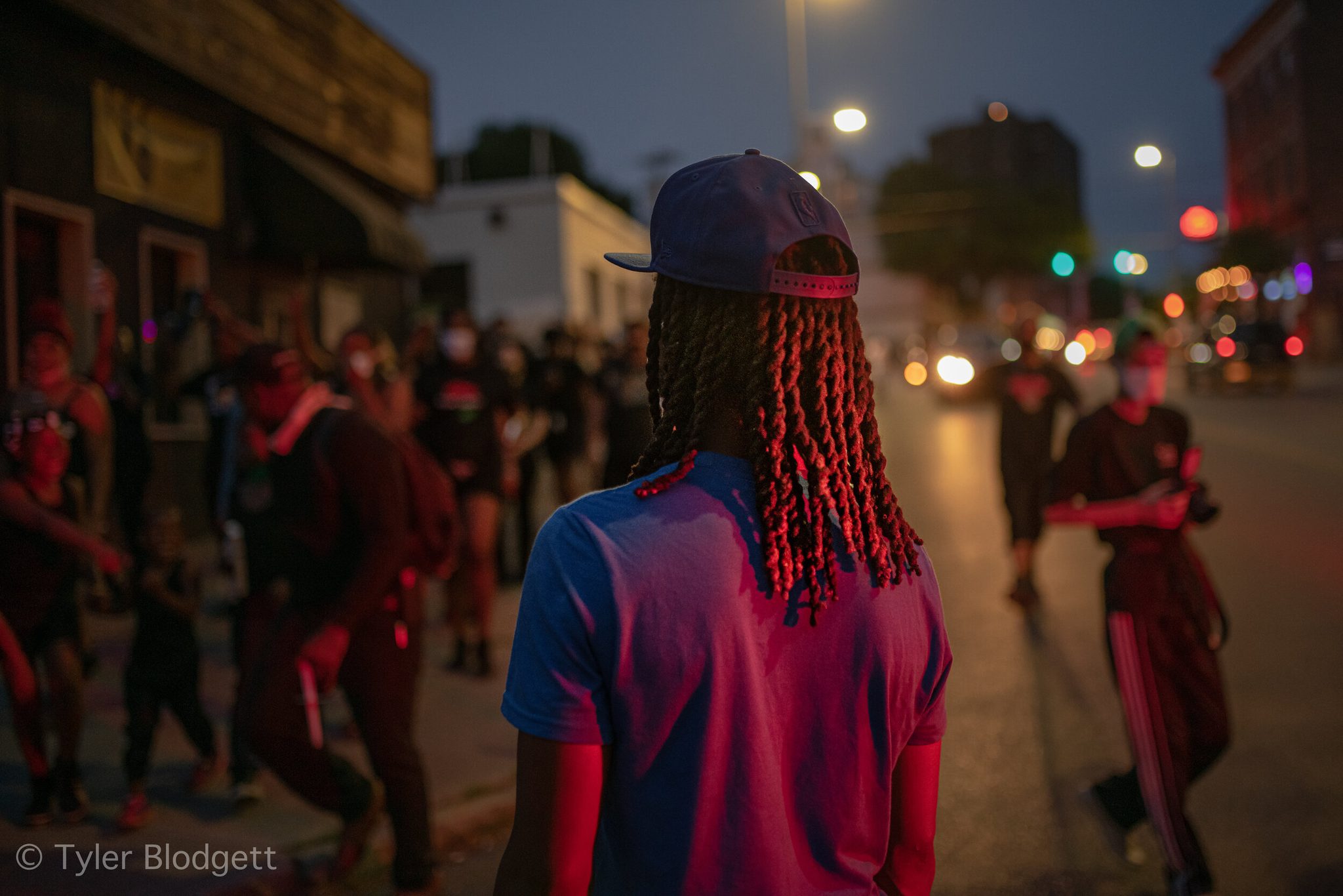 The march glows red under the streetlights at dusk.