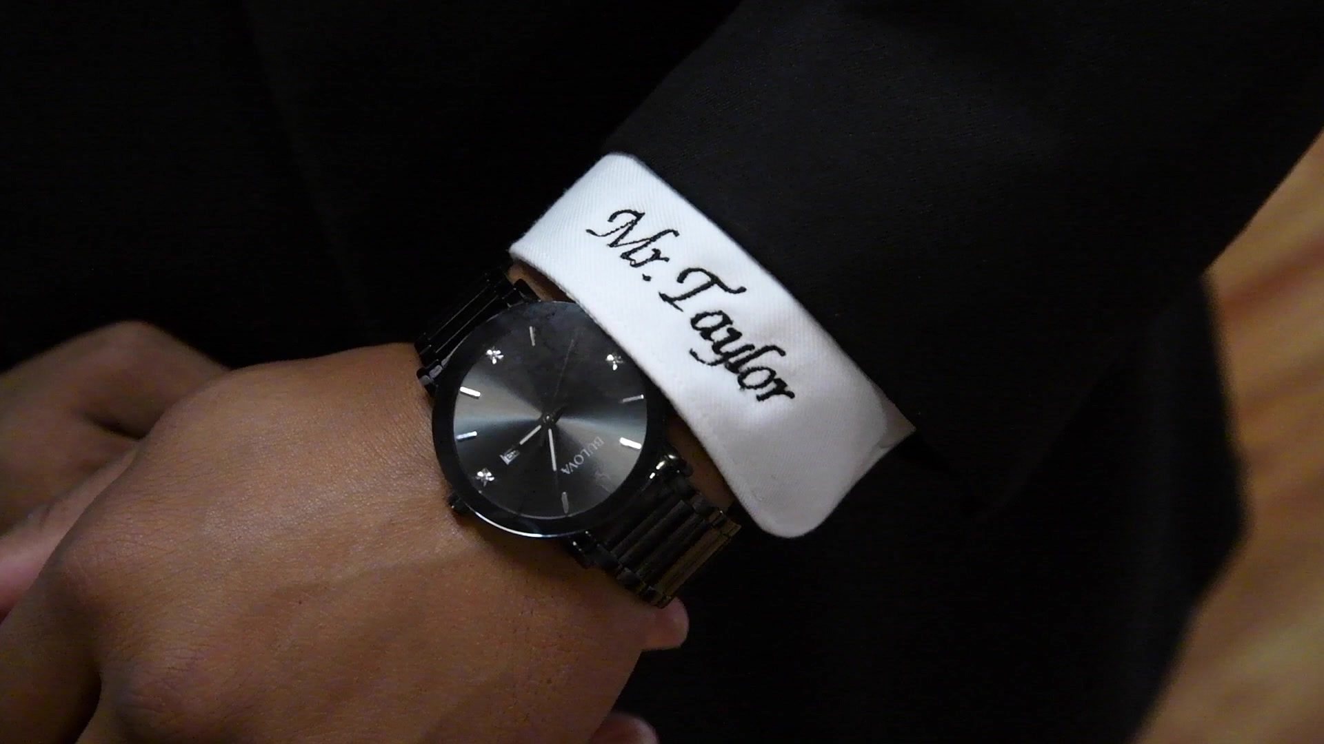 A place card tucked at the cuff reads Mr. Taylor.