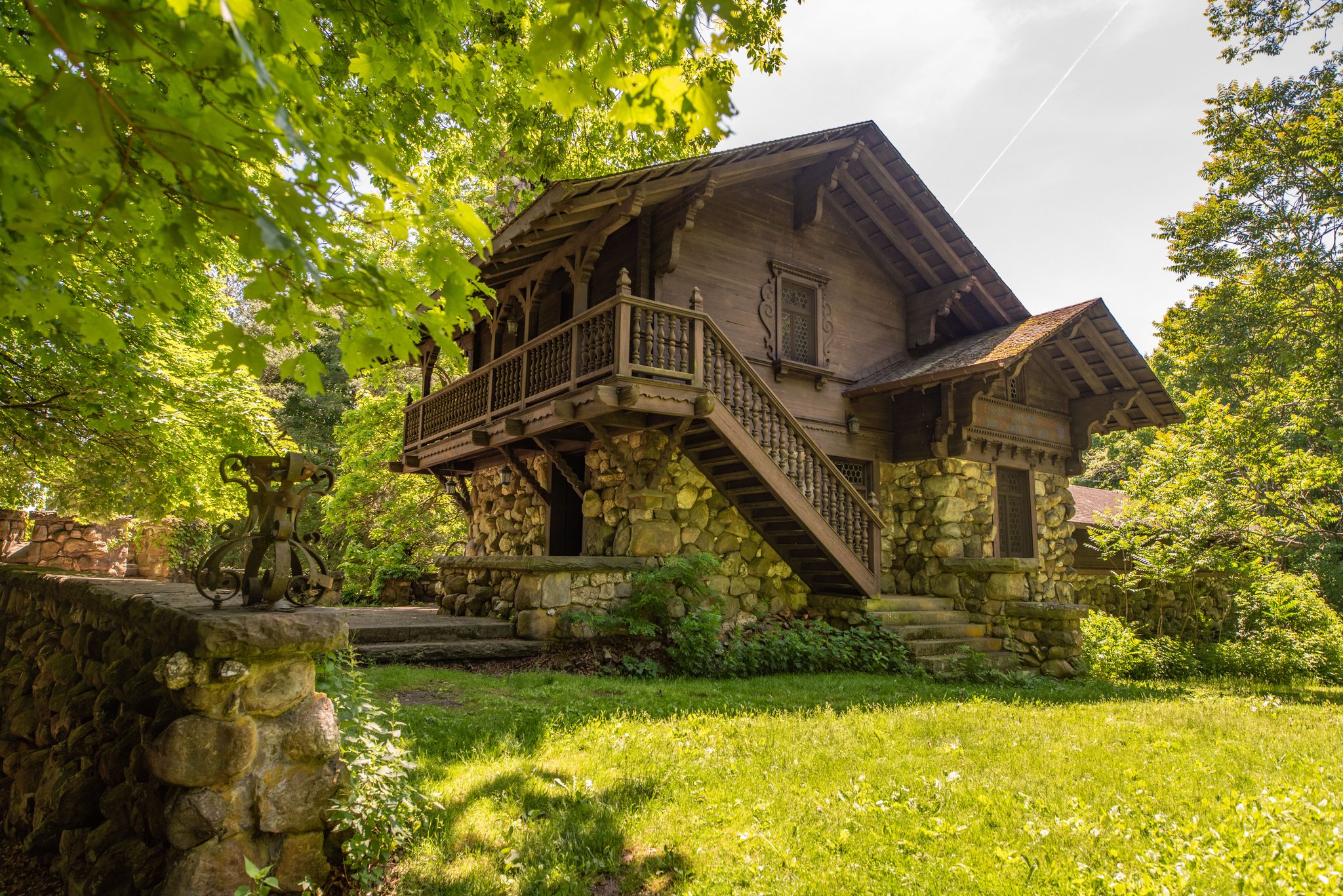 The bowling alley sits in a chalet-style building, carved timber balconies and an outside stair over walls of fieldstone.