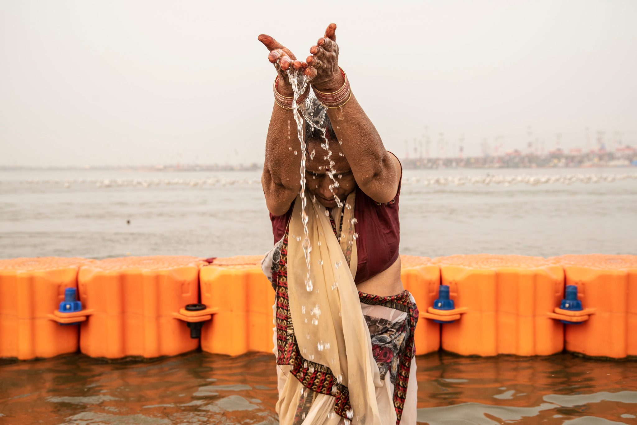 Woman pours the holy water of the Ganges from her hands