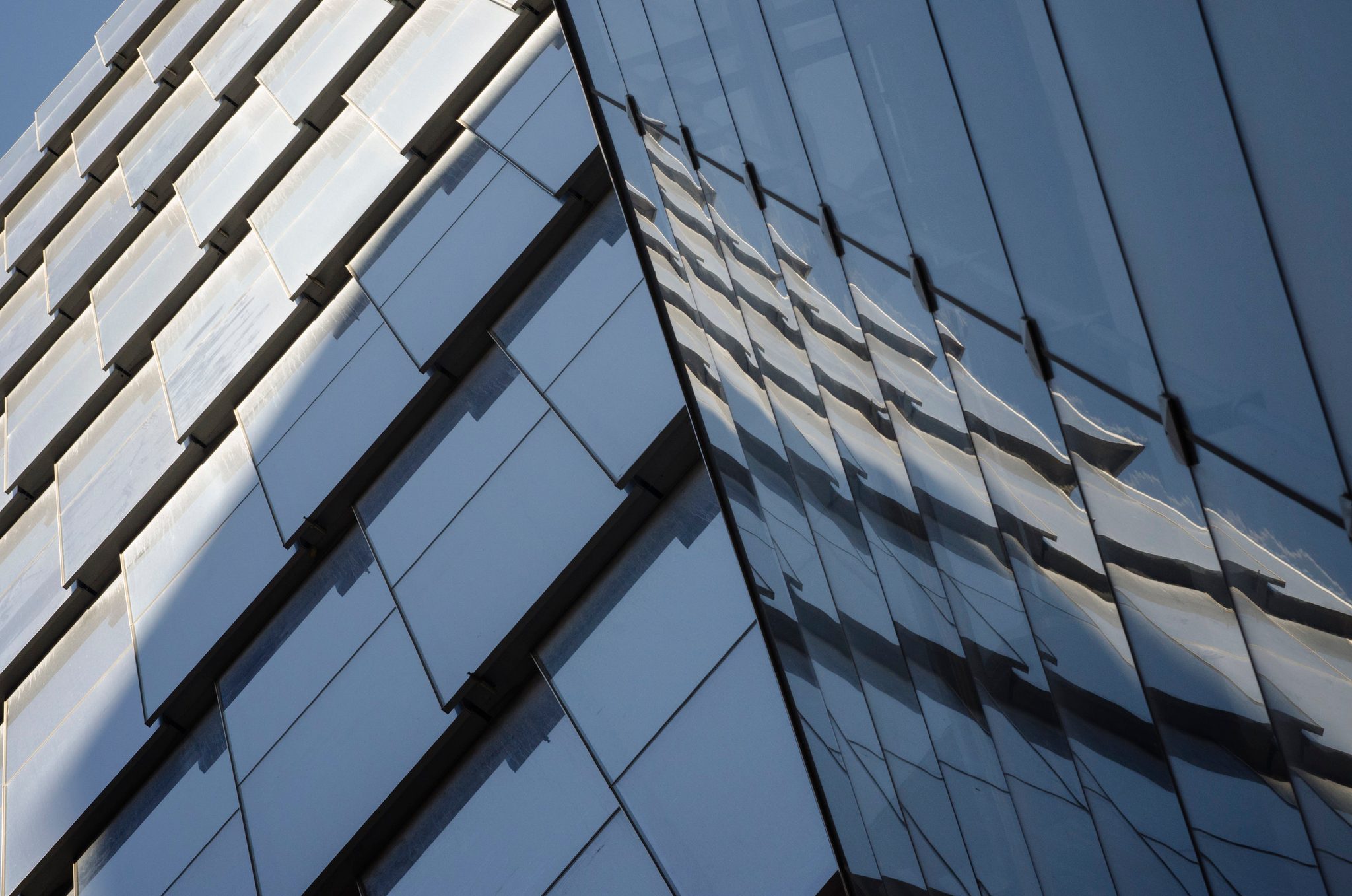 Glass panels fold and tilt across a facade, all angles and grids.