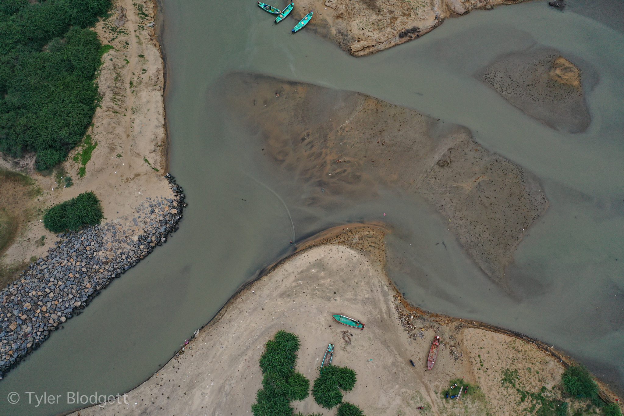 The channel curls past a stone embankment, seen from above.