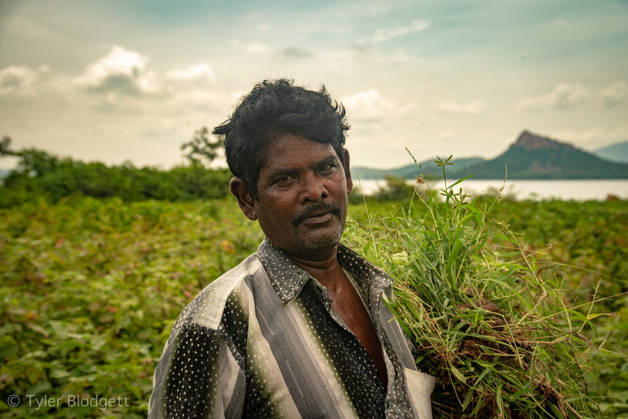 He looks back over his shoulder, the lake and the peak behind him.