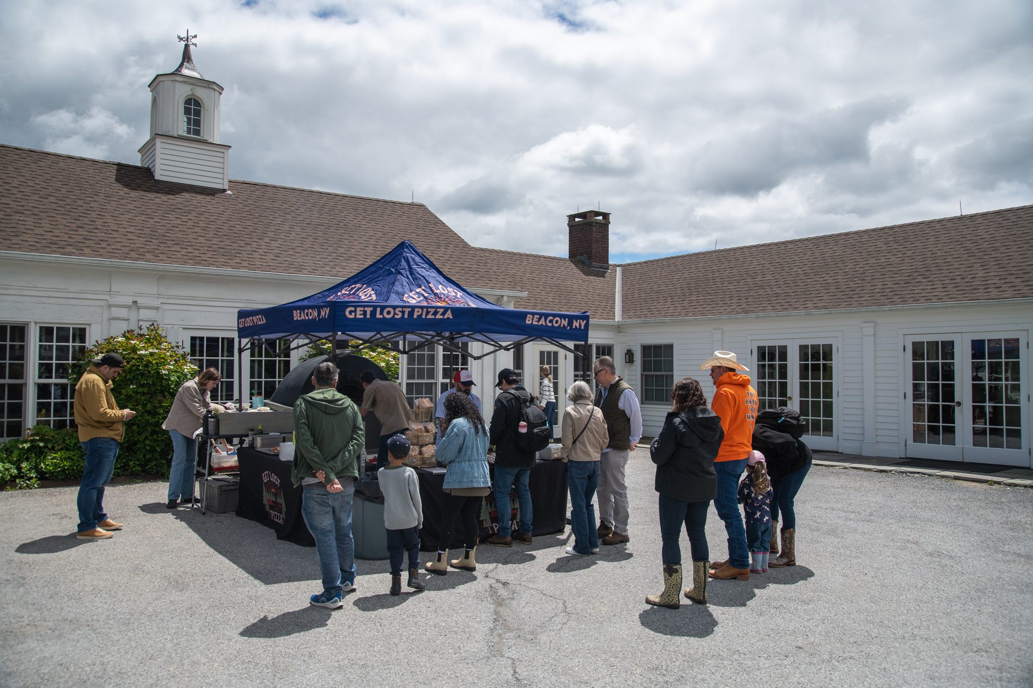 A line forms at the pizza tent in front of the white barn.