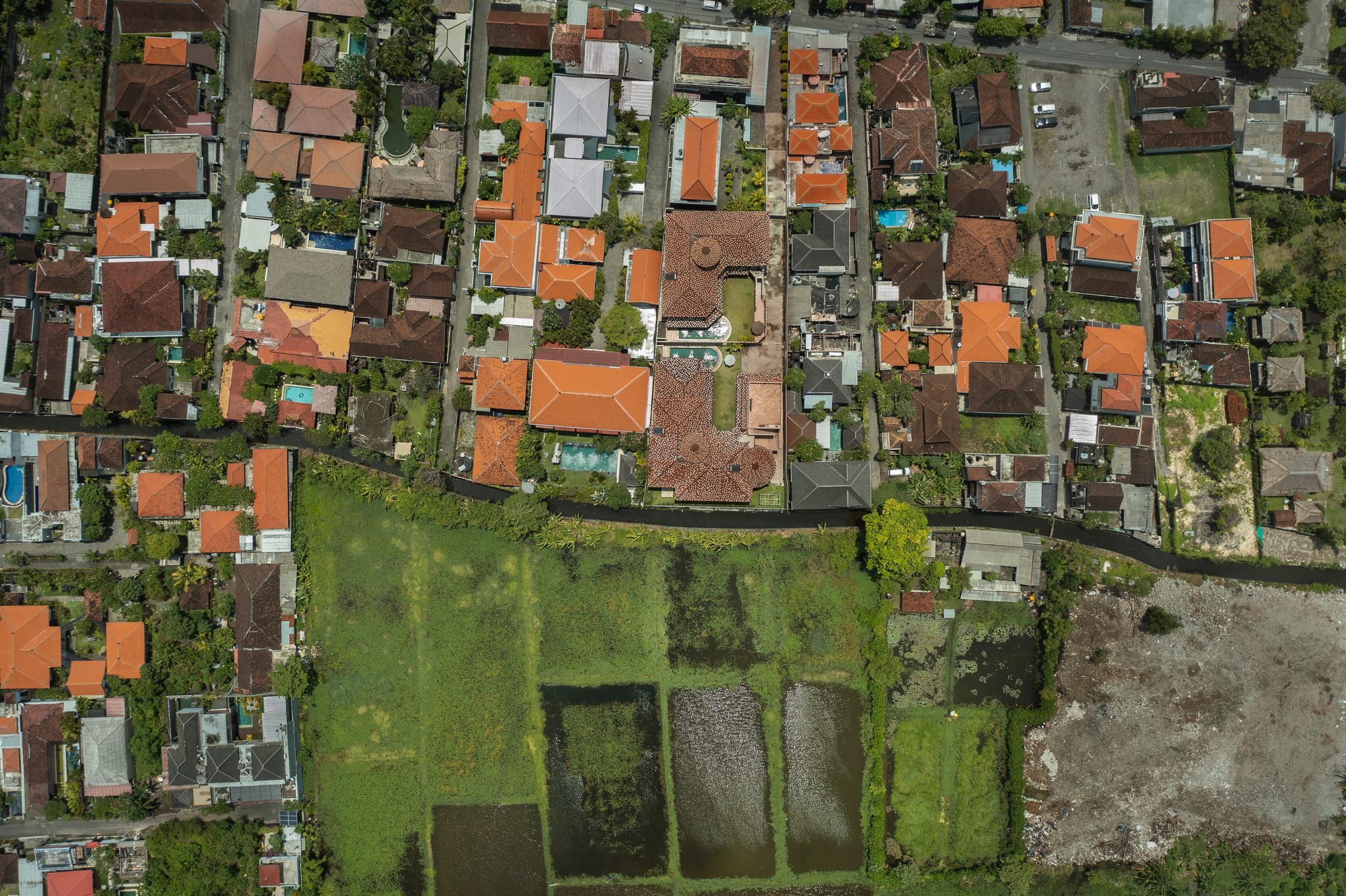 Orange roofs press right up to the last rectangles of green.