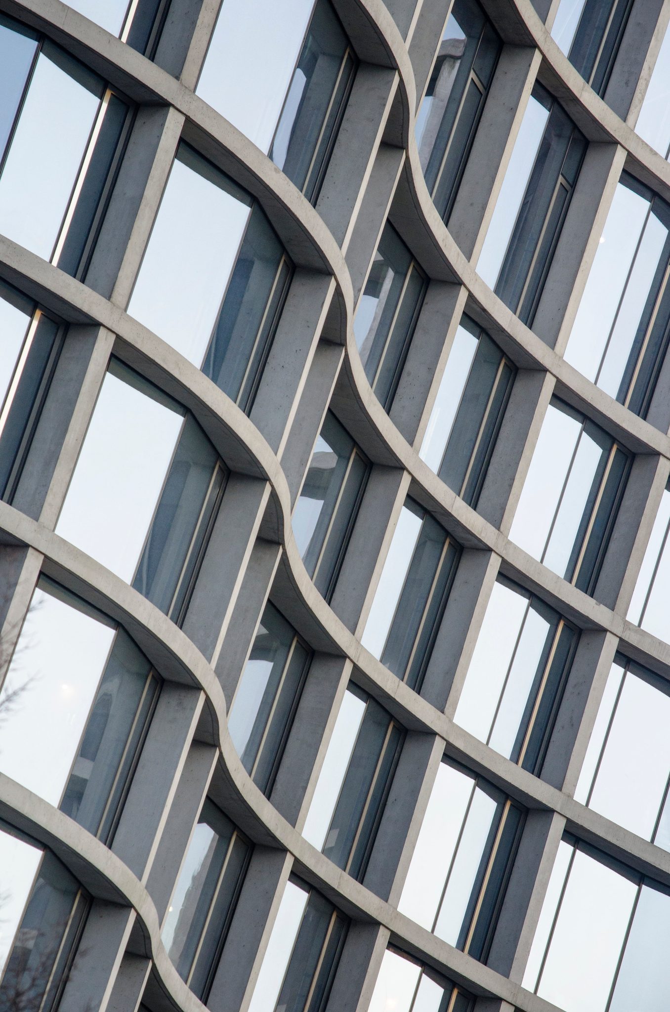 A facade of glass ripples like a curtain in the wind.