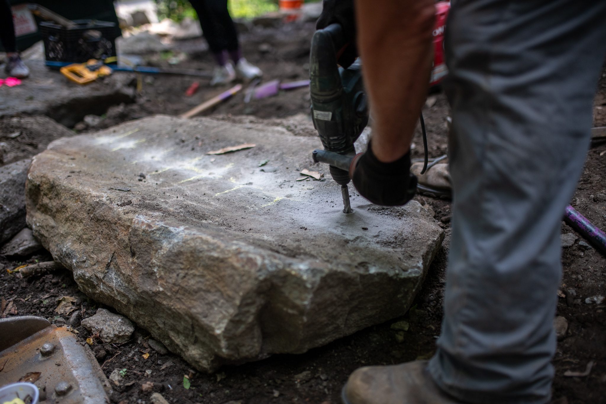 The drill bites into the rock, one hole after another.