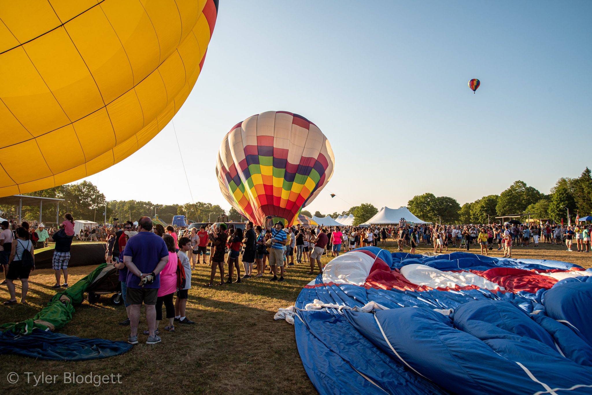 Envelopes swell across the field as the crowd wanders between them.