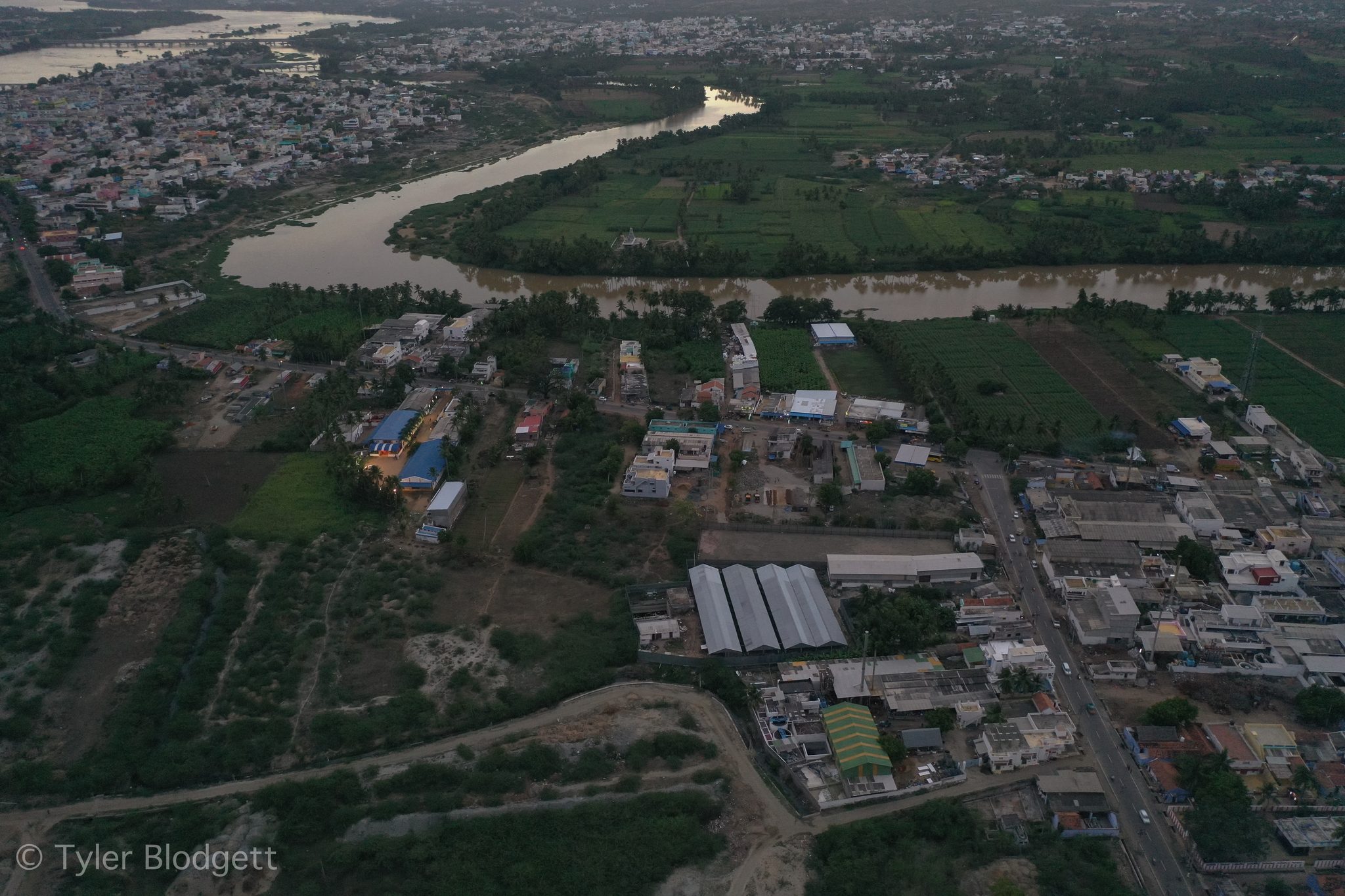 The town crowds the riverbank, the water curving away into the haze.