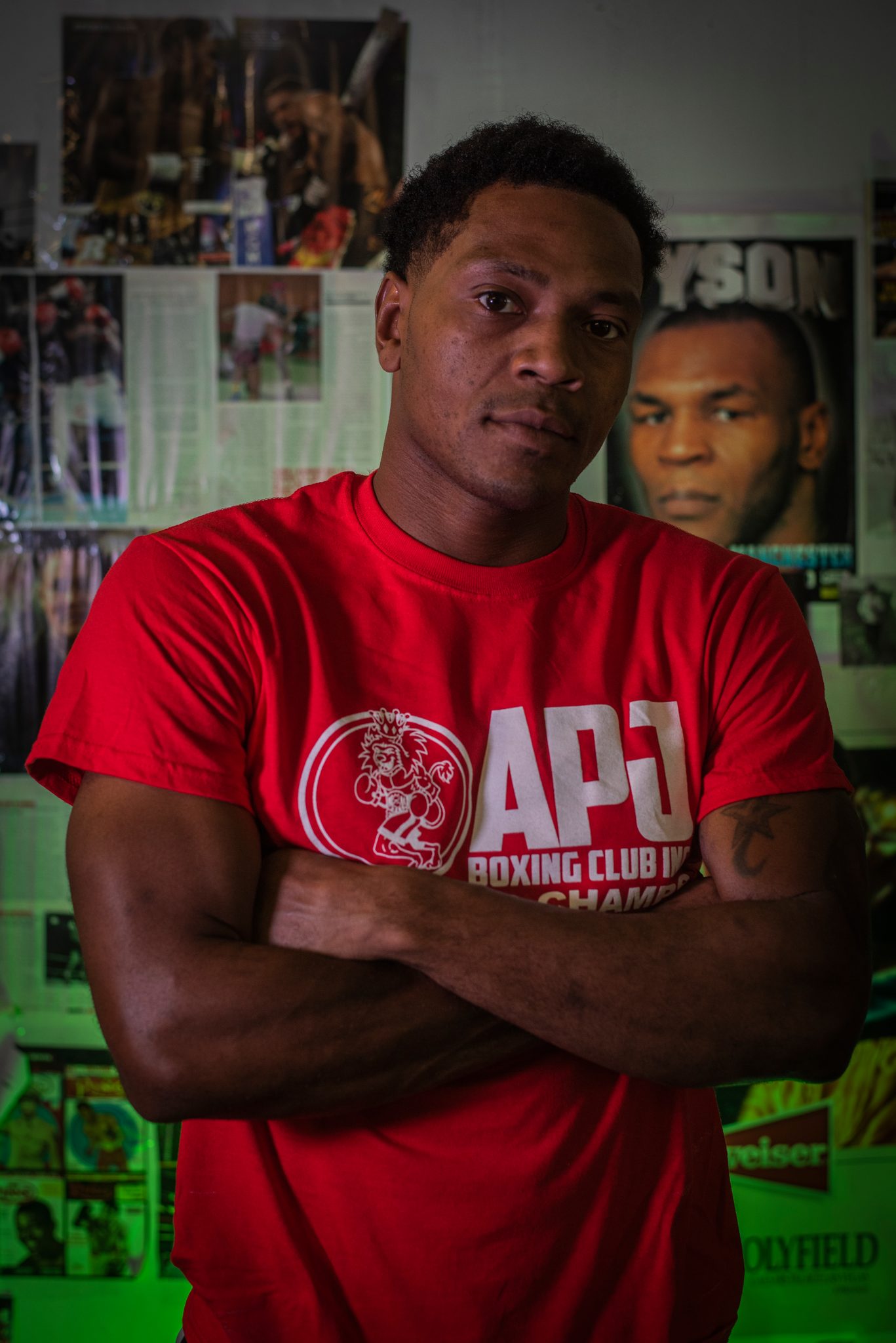 Arms folded, Tyson's poster just over his shoulder.