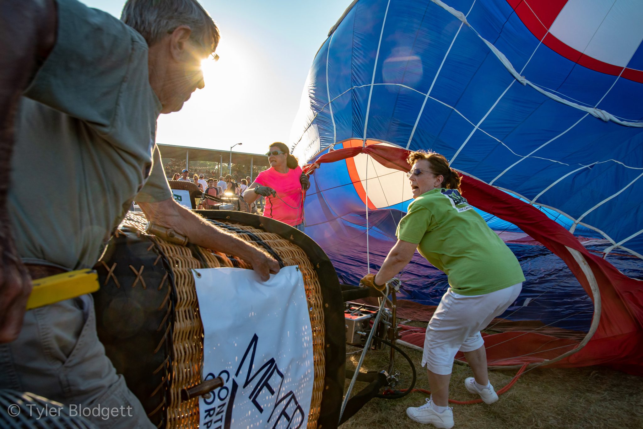 The crew hauls the basket upright as the envelope fills.