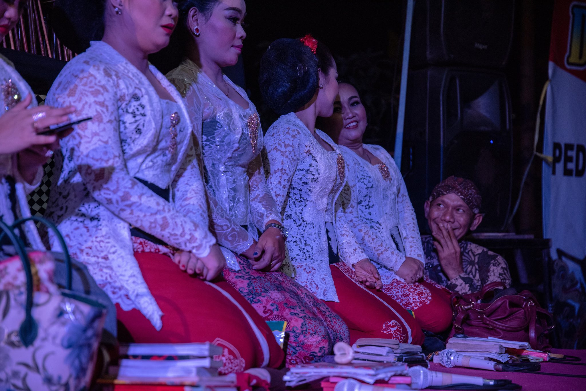 The singers kneel in a row of white lace, and at the end of the line an elder in a headcloth can't hide his smile.