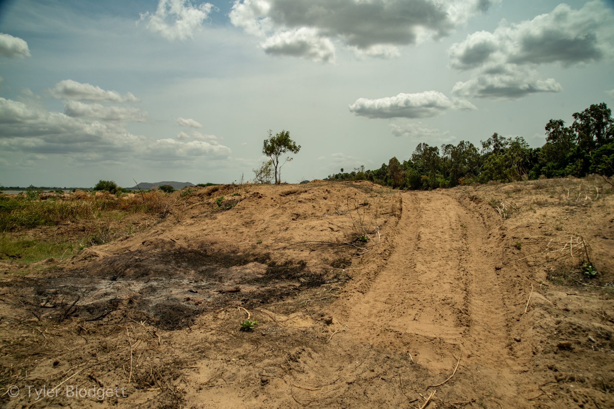 A dirt track climbs over the dry, burned ground.