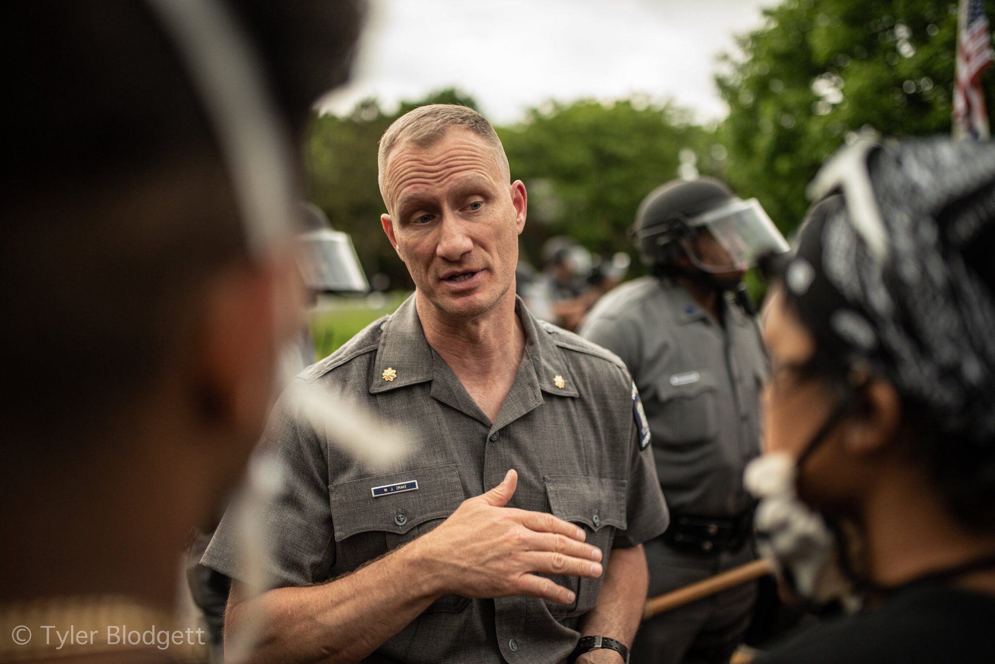 A state police officer puts a hand to his chest as he talks with the marchers.