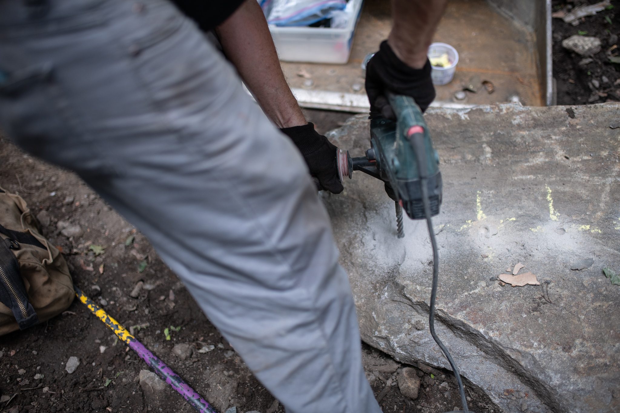 Dust lifts as the drill works through the granite.
