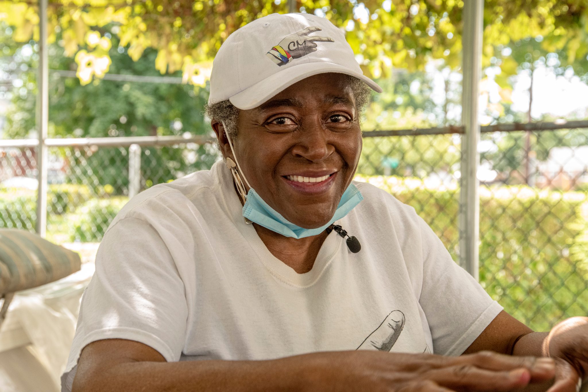 An elder in a CM2 shirt laughs on the porch.