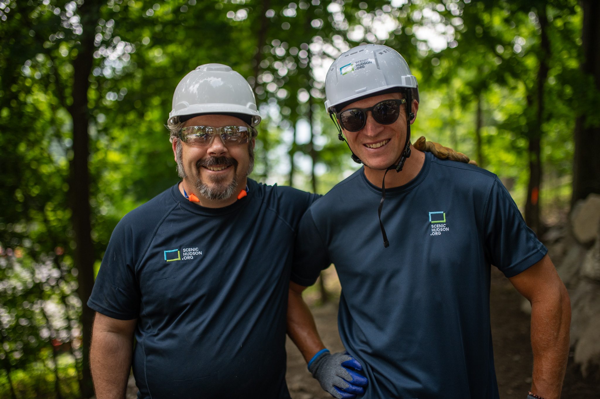 Arms around each other's shoulders, two crew members smile for the camera.