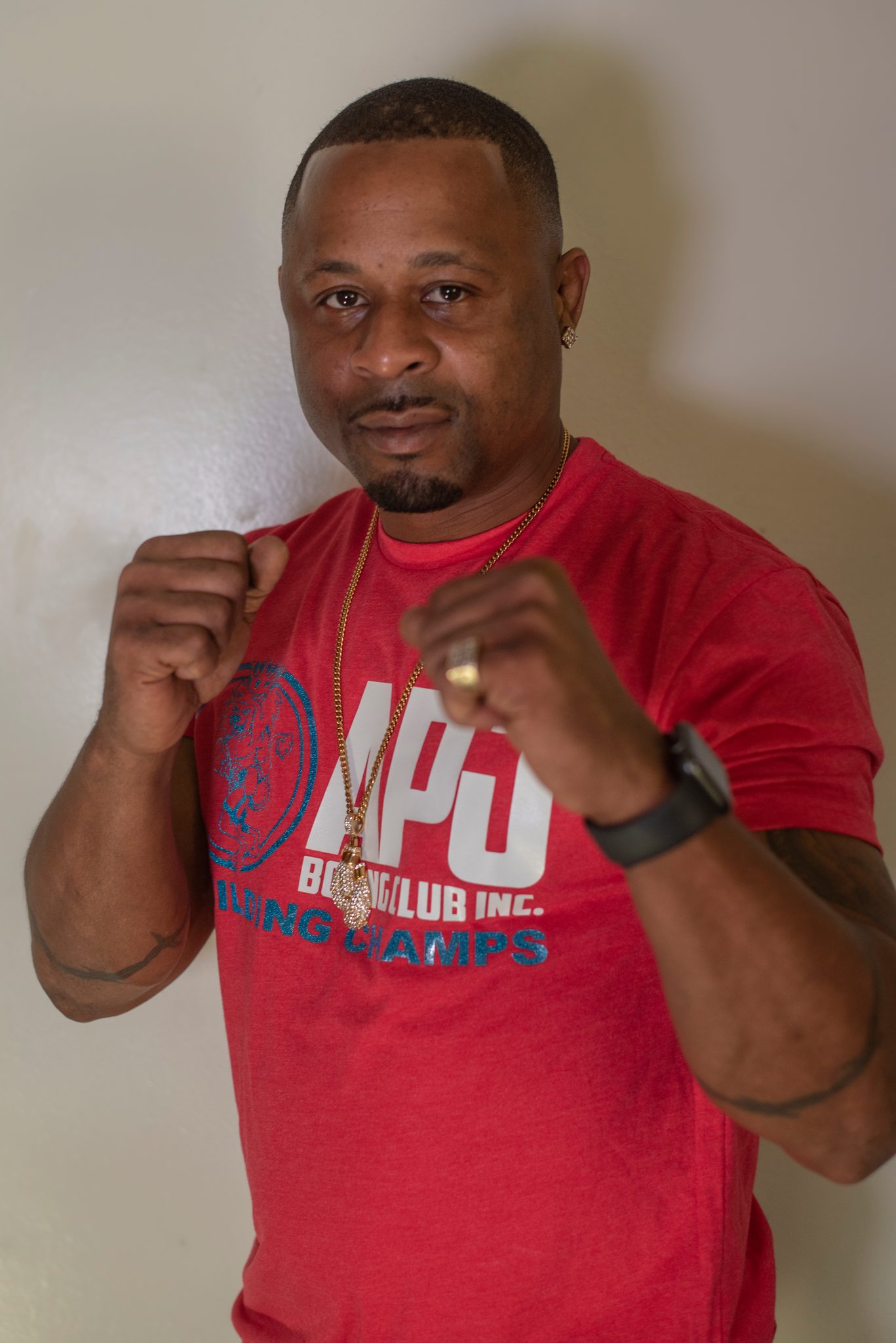 Fists up, a watch on one wrist and a ring on the other.