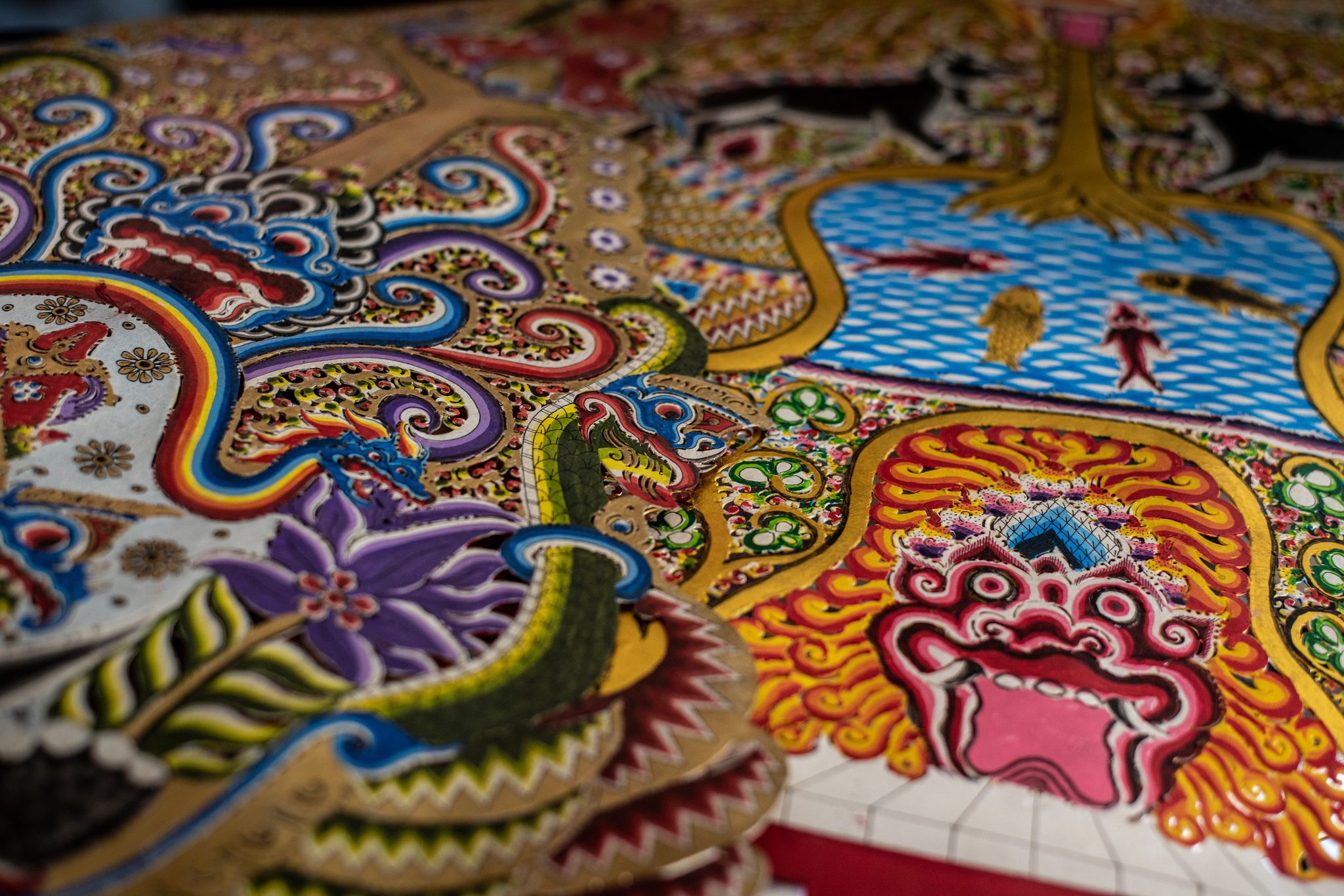 Every inch of the painted leather is crowded with dragons, fish and flame.