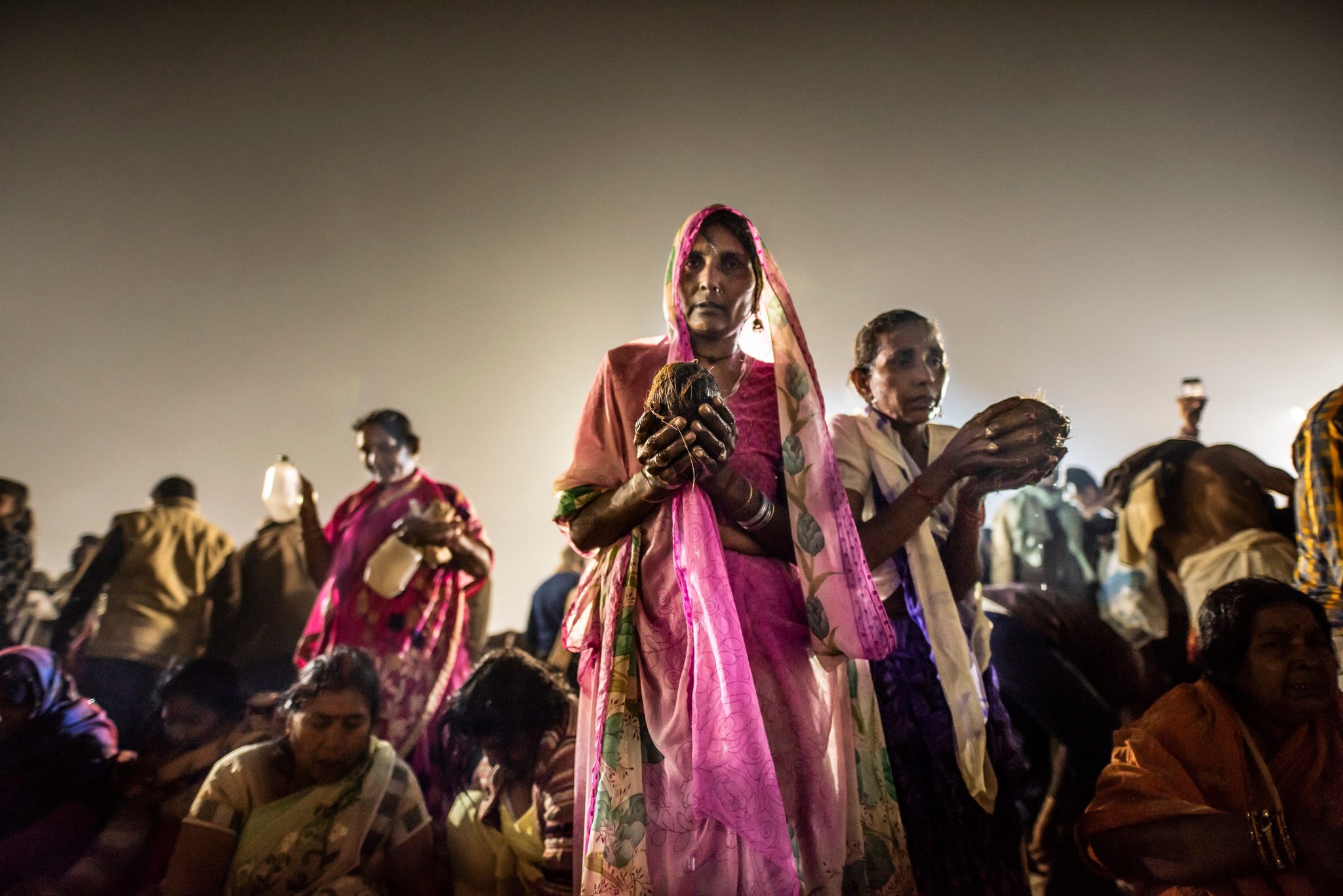 Women push through the crowd to bring puja offerings to the Ganges.