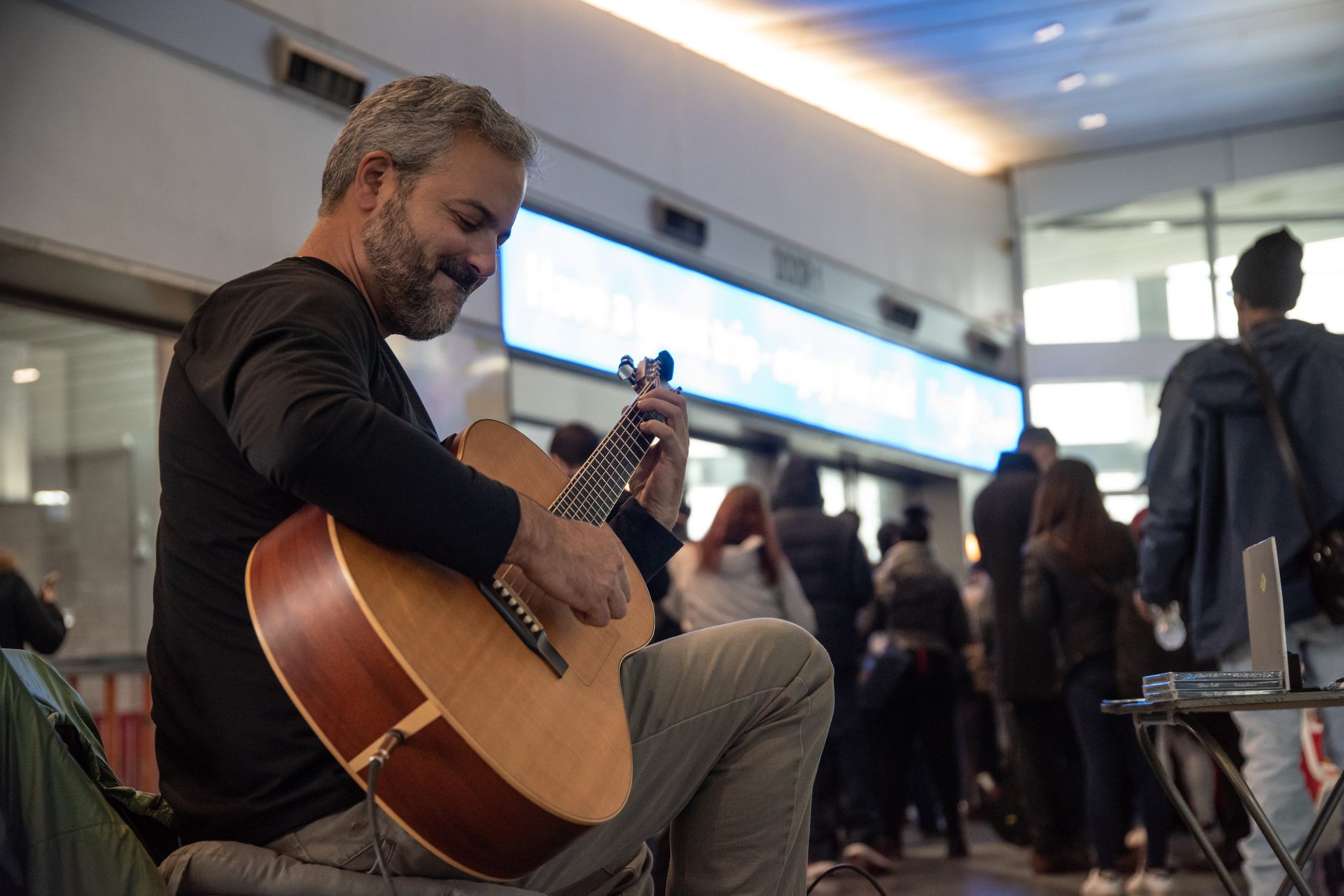 Glenn smiles down at the strings while the ferry crowd lines up behind him.