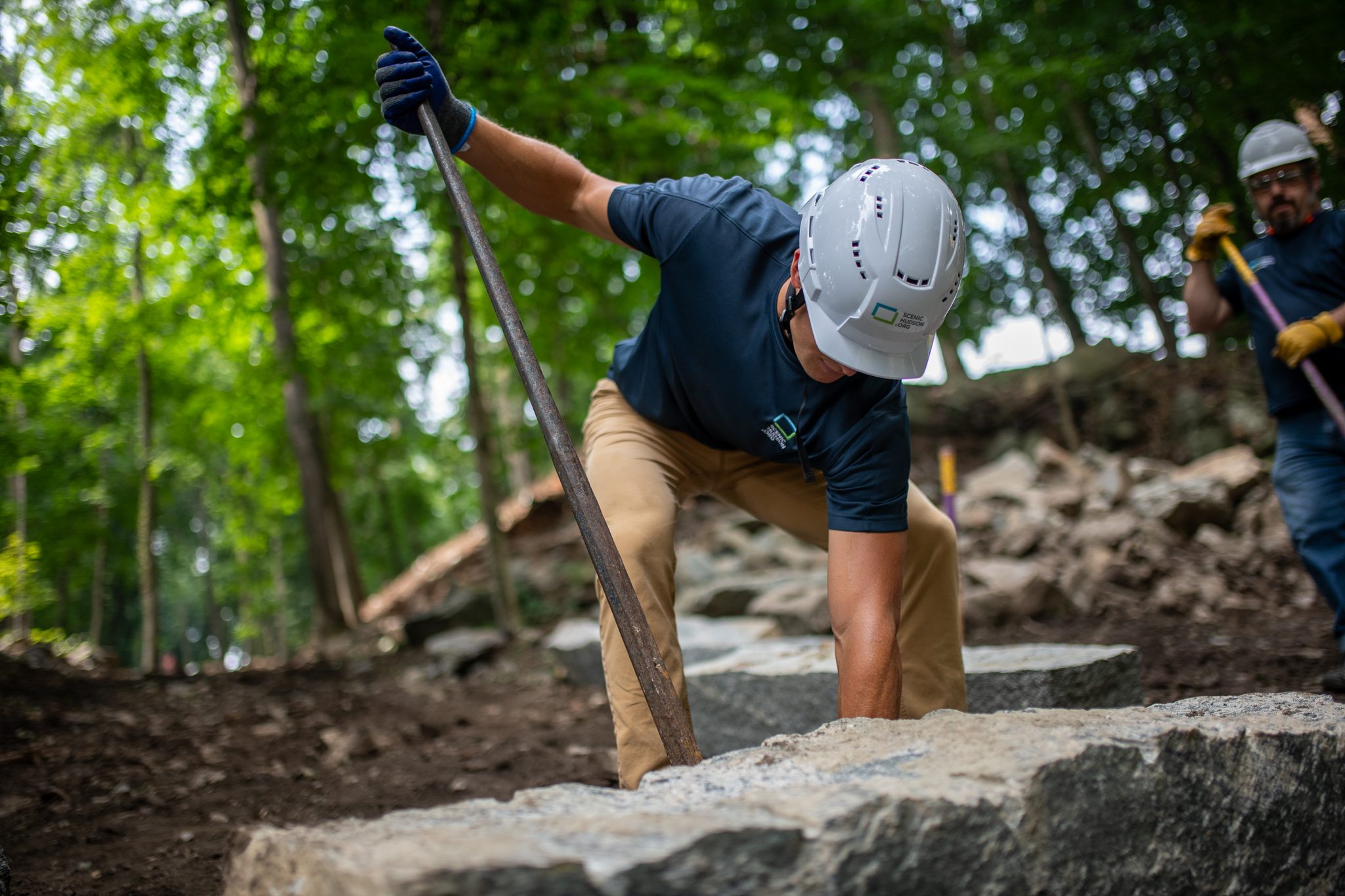He leans on the bar and grins, a granite step at his feet.