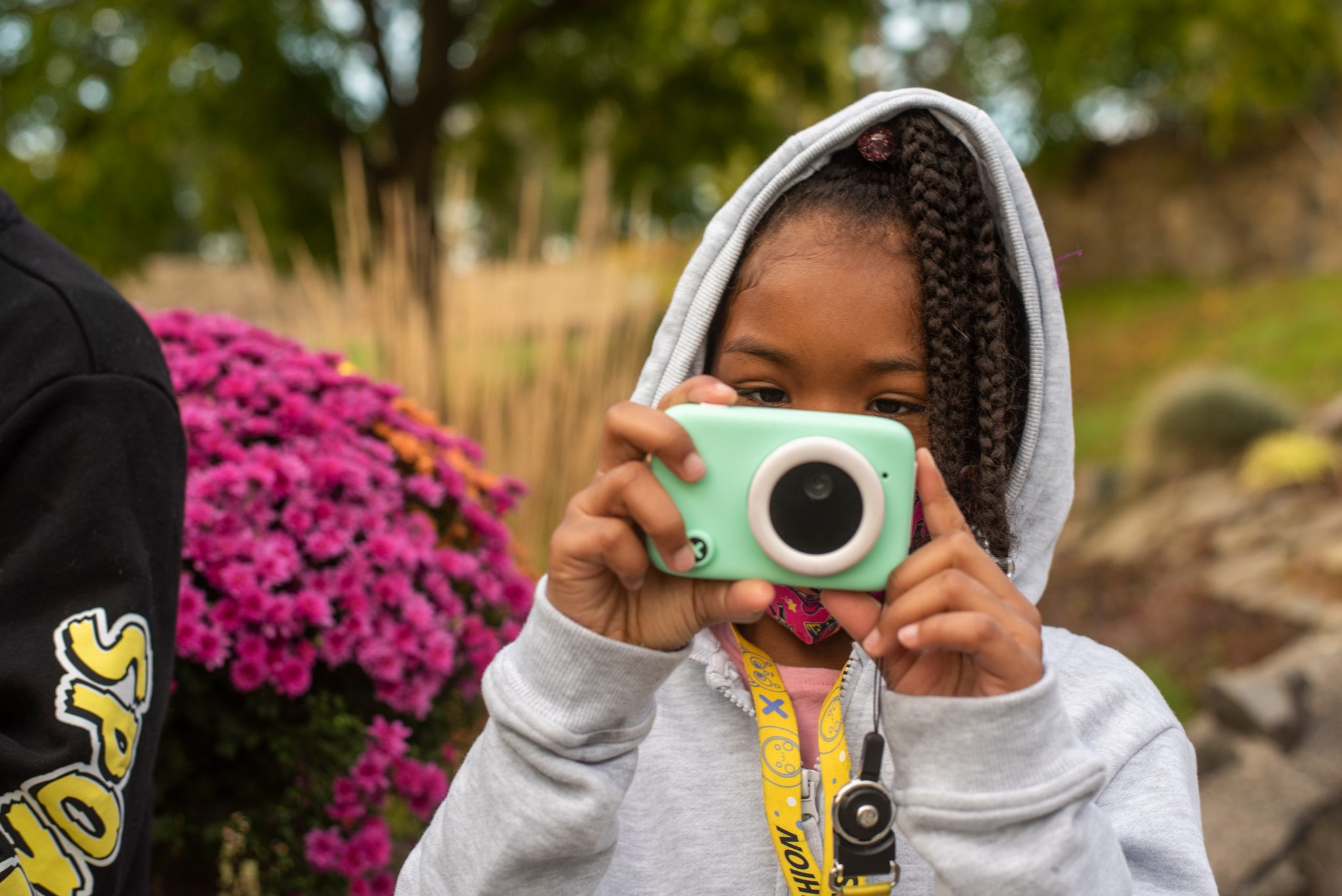 A young photographer lines up her shot beside the mums.