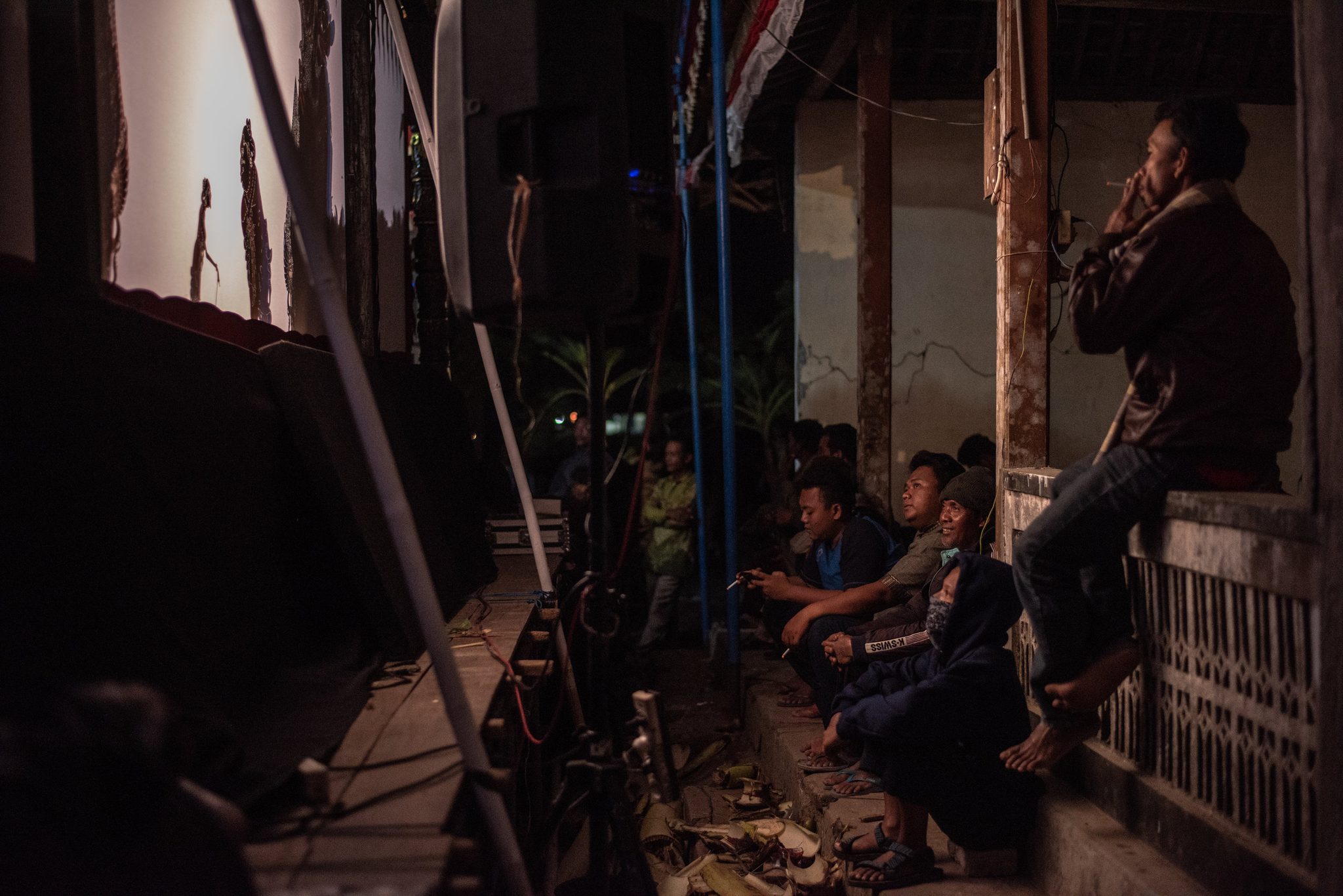 Enthusiasts gather behind the screen to watch the performance the traditional way