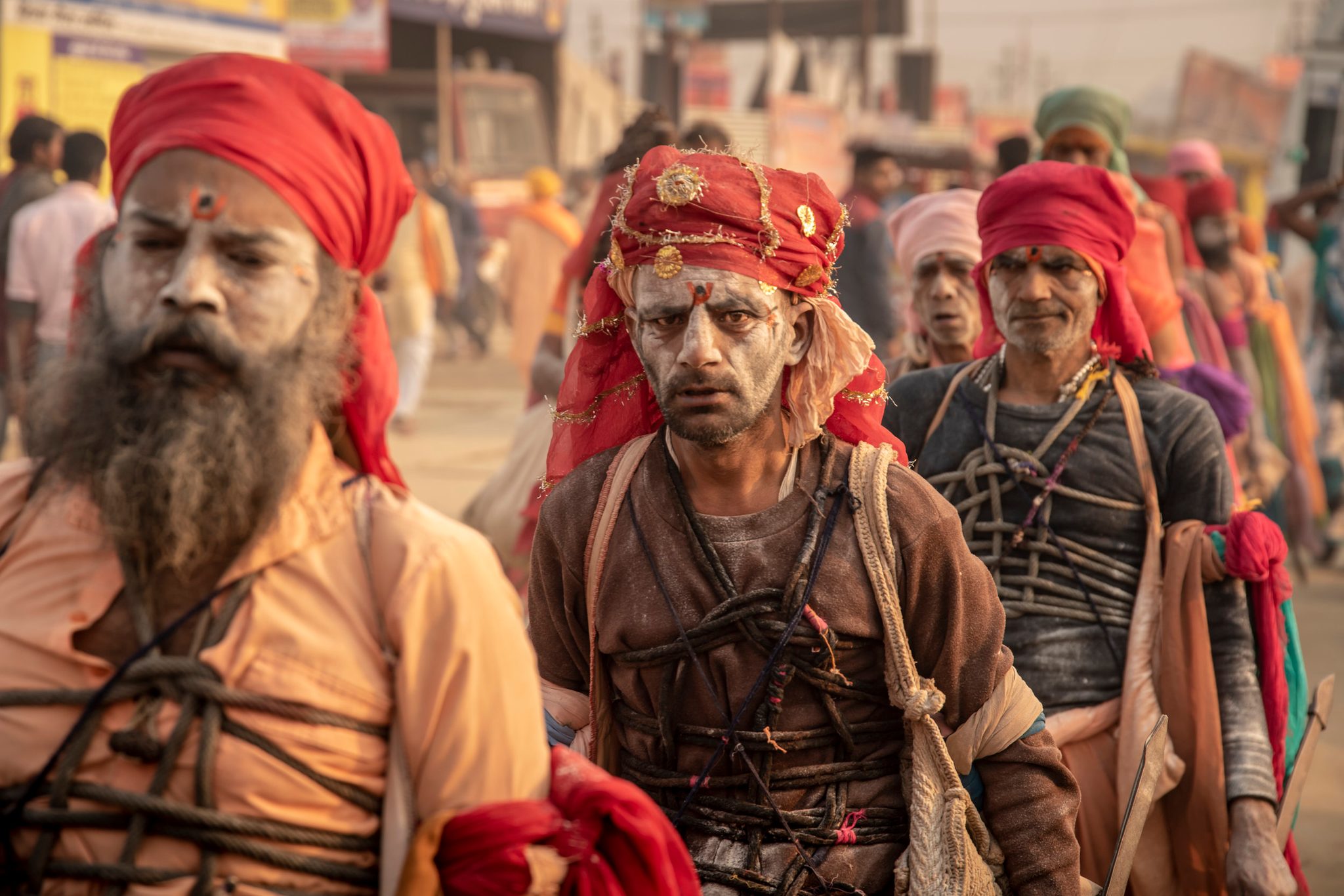 Sadhu’s bound in decorative rope march through the mela center.