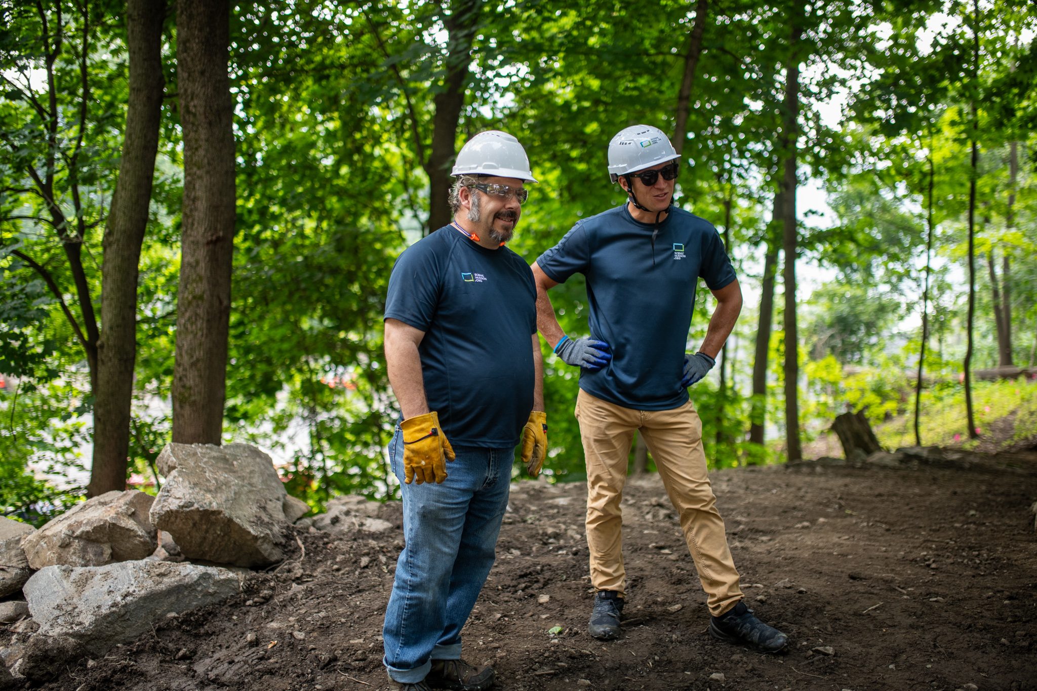 Two men in hard hats share a grin between tasks.