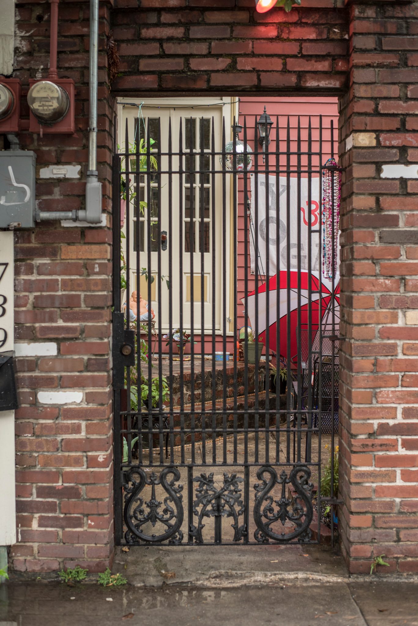 Behind a wrought iron gate, a pink door and a painted pair of red lips.