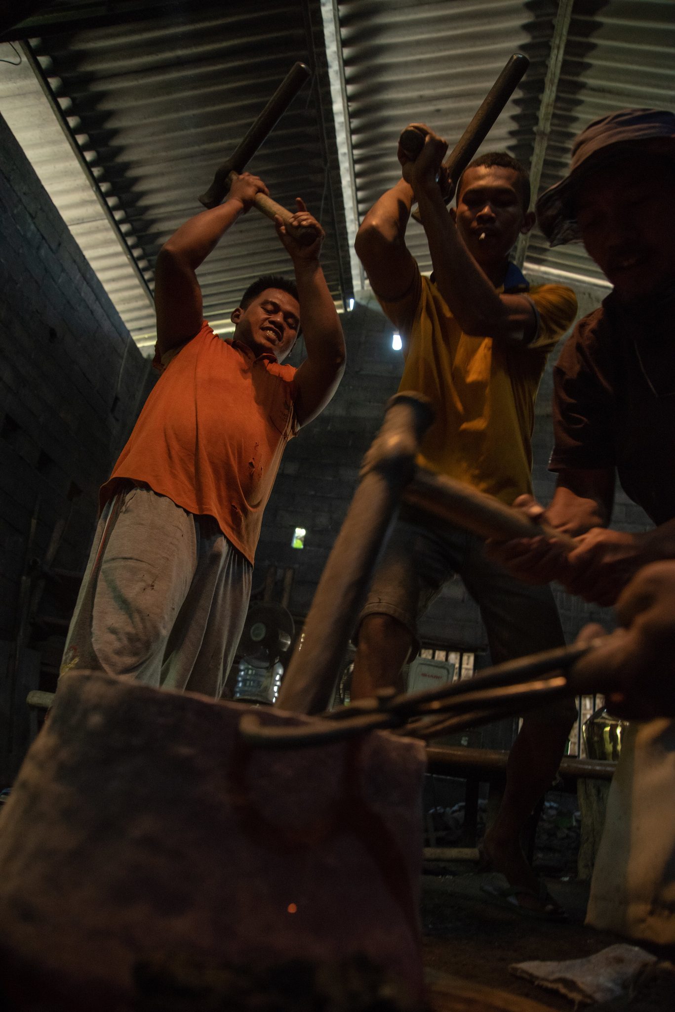 Seen from below, the hammers swing high over the anvil.
