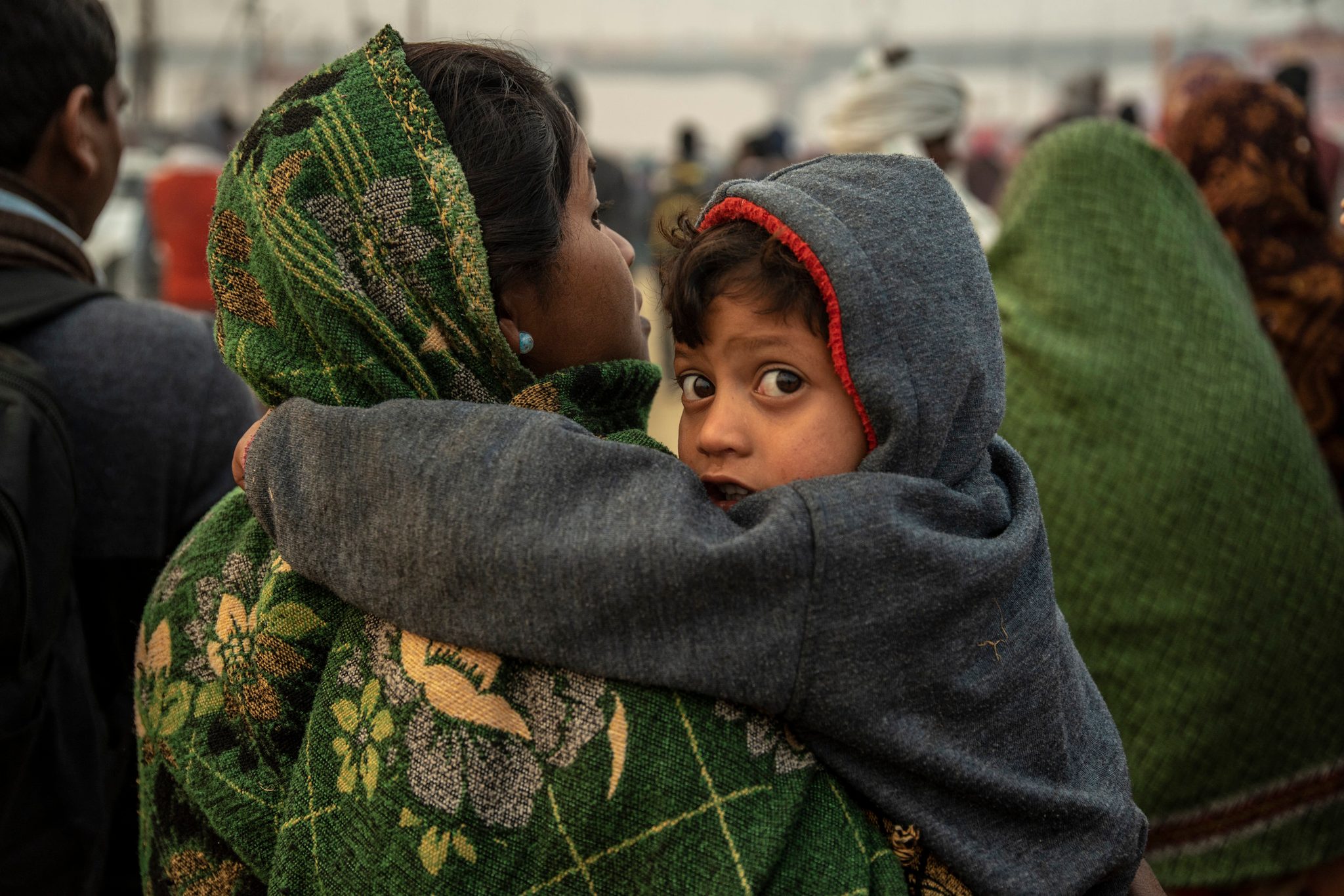 Mother and child march towards the center of the mela