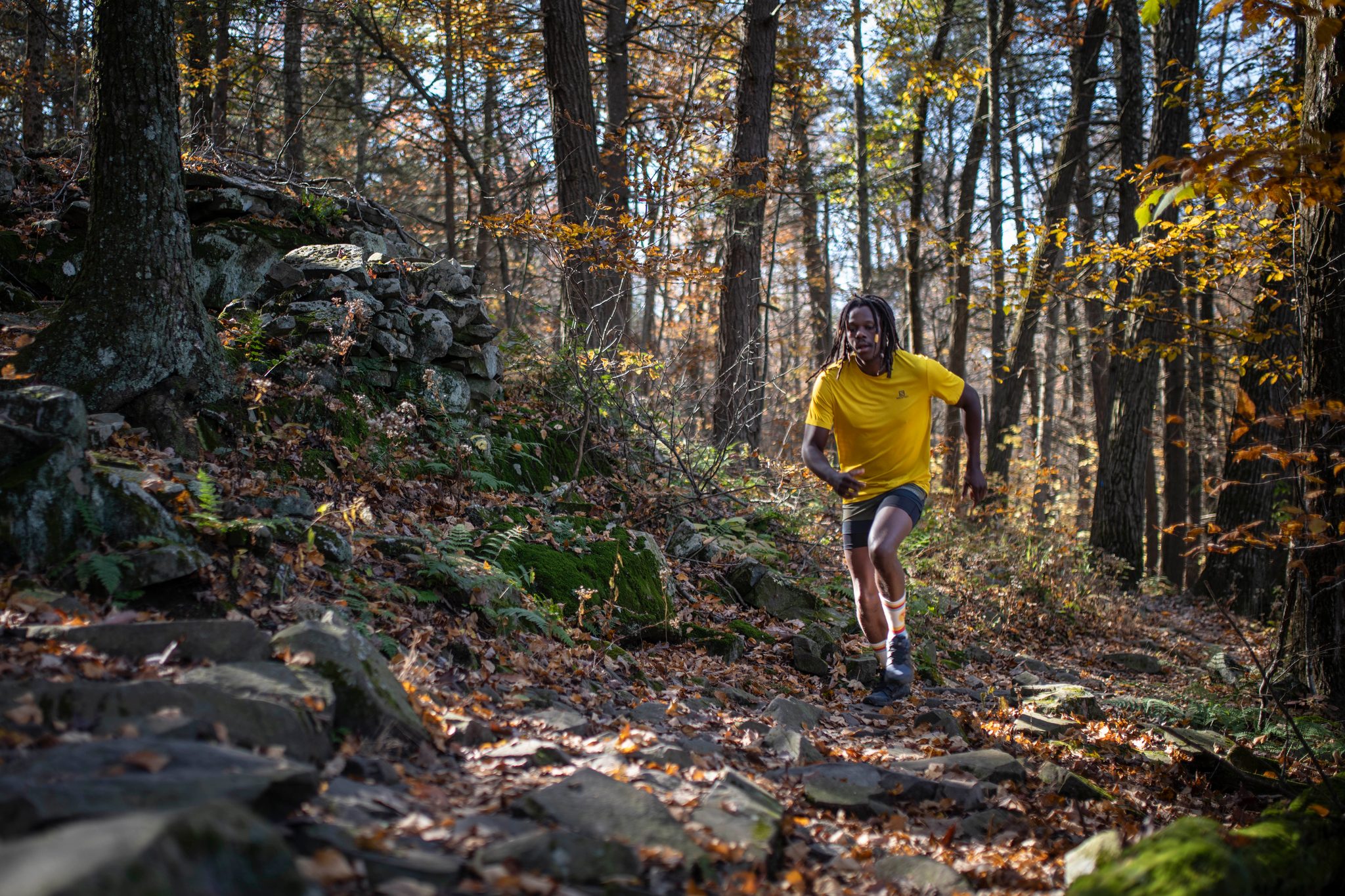 He bounds down the rocky trail through the turning leaves.