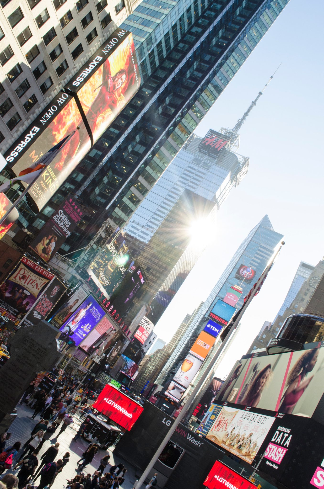 Times Square's billboards stack toward the sun, an altar to opulence.