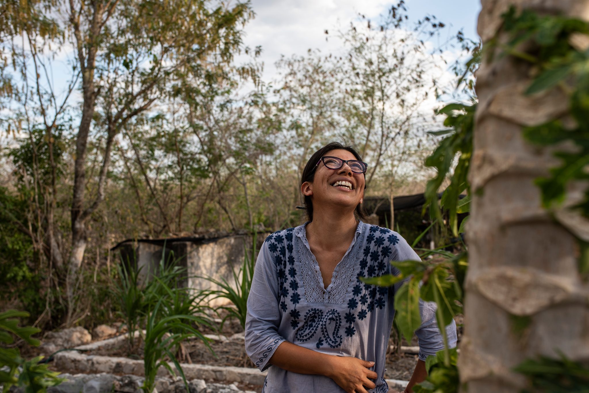 She tips her head back and laughs in the garden.