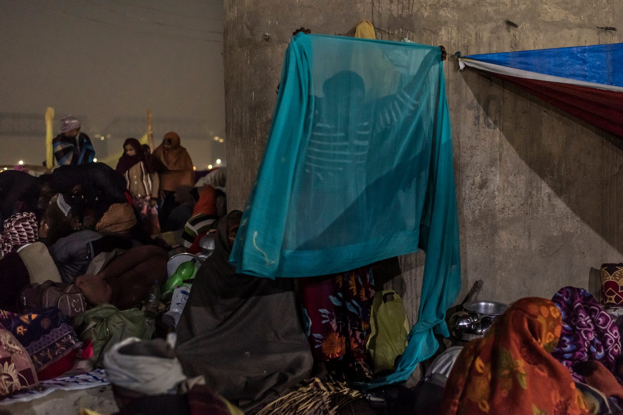 Woman folds fabric in preparation for the morning walk to the river.