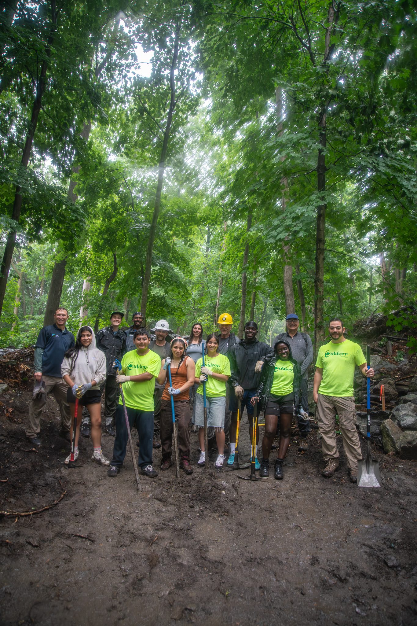 Shovels, pry bars and hard hats: the whole crew in the green shade of the woods.