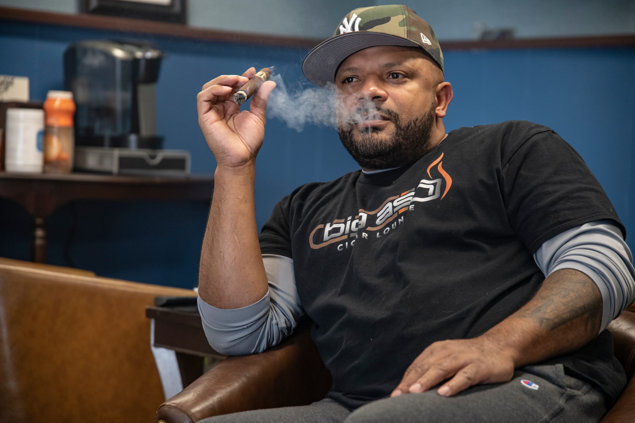 Smoke curls from a cigar as the conversation goes on.