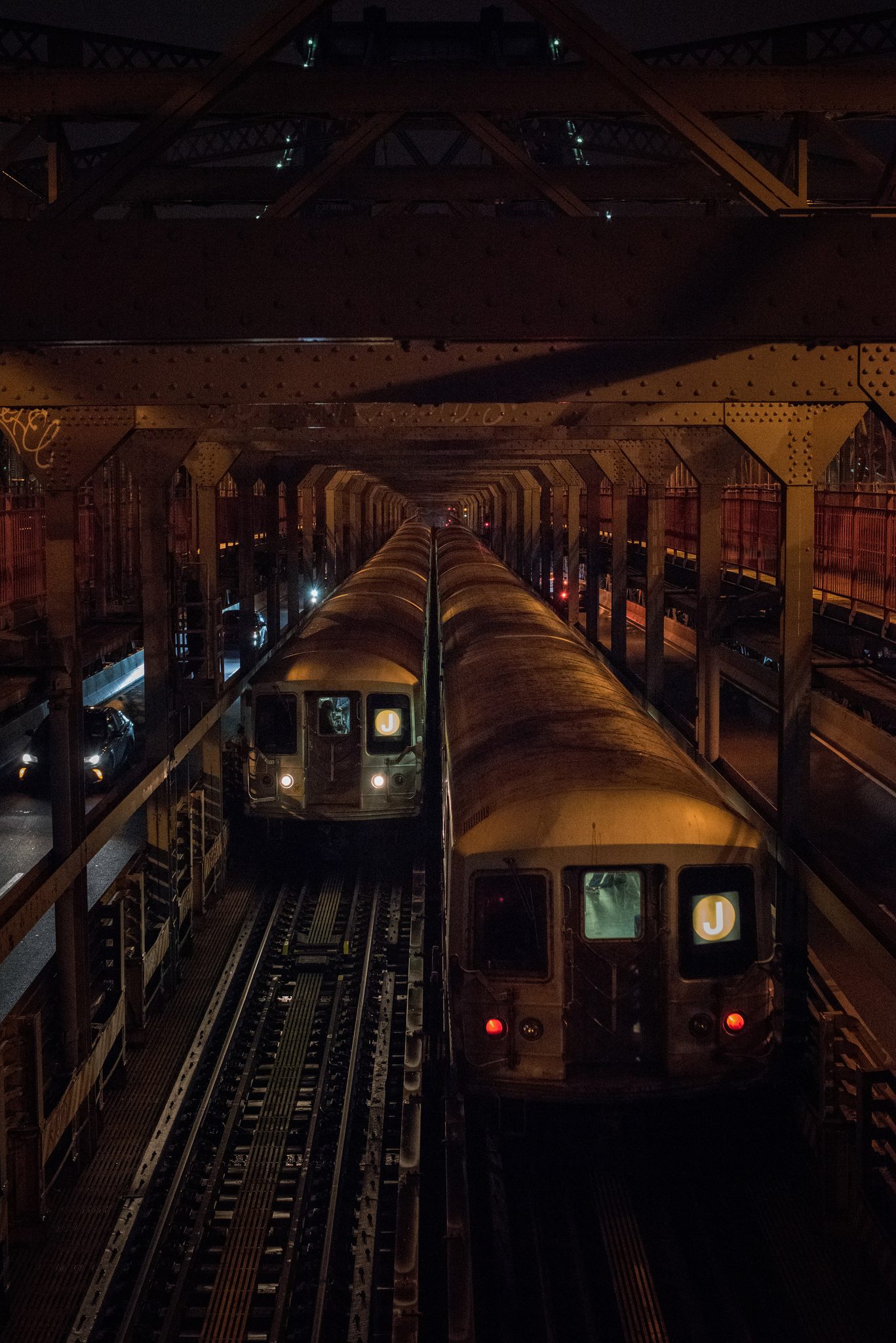 Two trains meet inside the iron ribs of the Williamsburg Bridge. Somewhere above the East River, Brooklyn and Manhattan trade passengers.