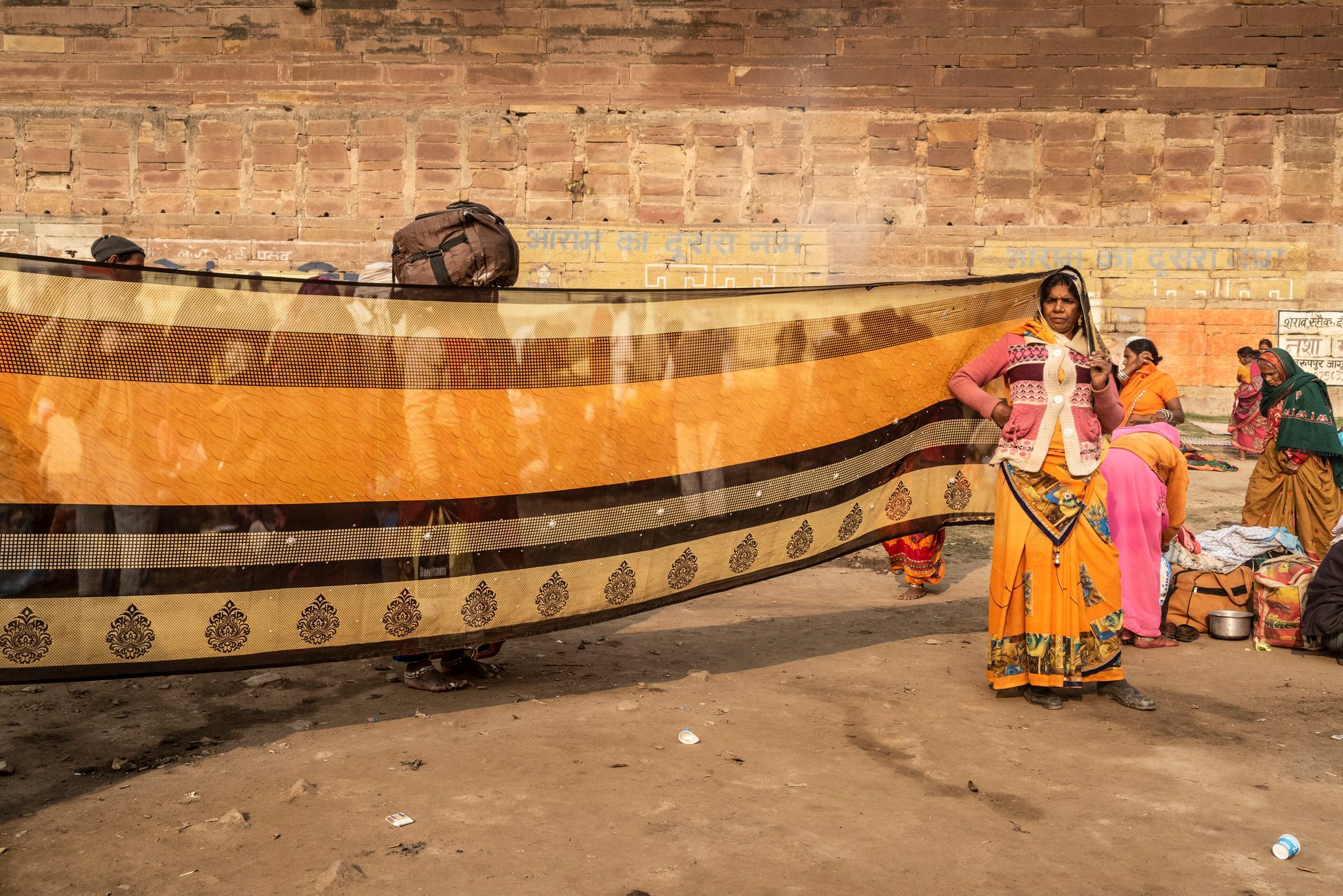 A woman dries her bright orange saree in the midday sun, likely after dipping it in the Ganges during her morning trip to Sangam. This strange yet beautiful occurrence became common place by the time I’d left the Kumbh. I will always remember these little moments which pop with color and mystery.