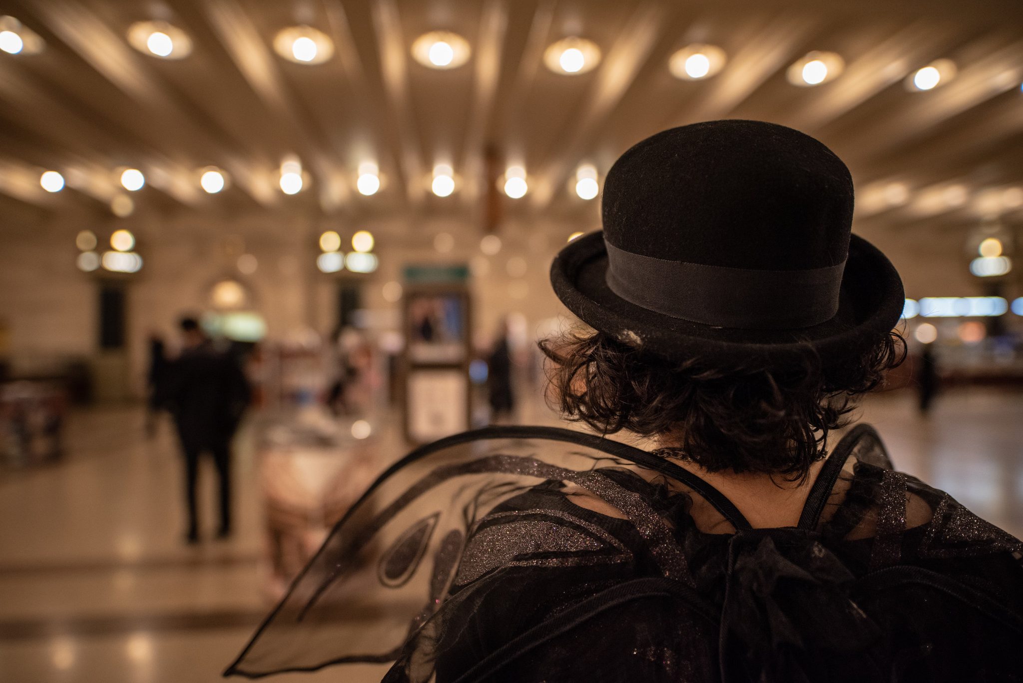 Gauzy wings and a bowler hat, she walks out into the terminal.