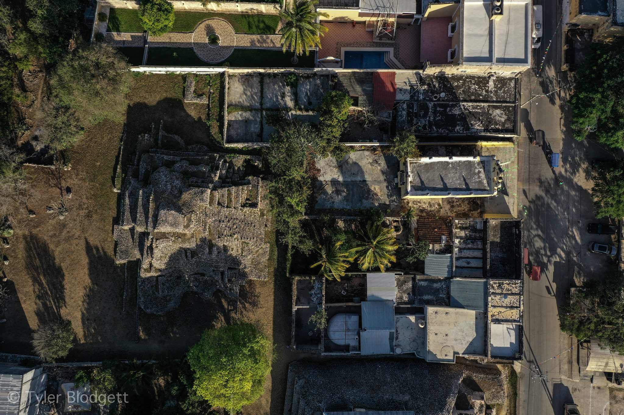 Straight down from the sky, rooftops and courtyards line a quiet street.