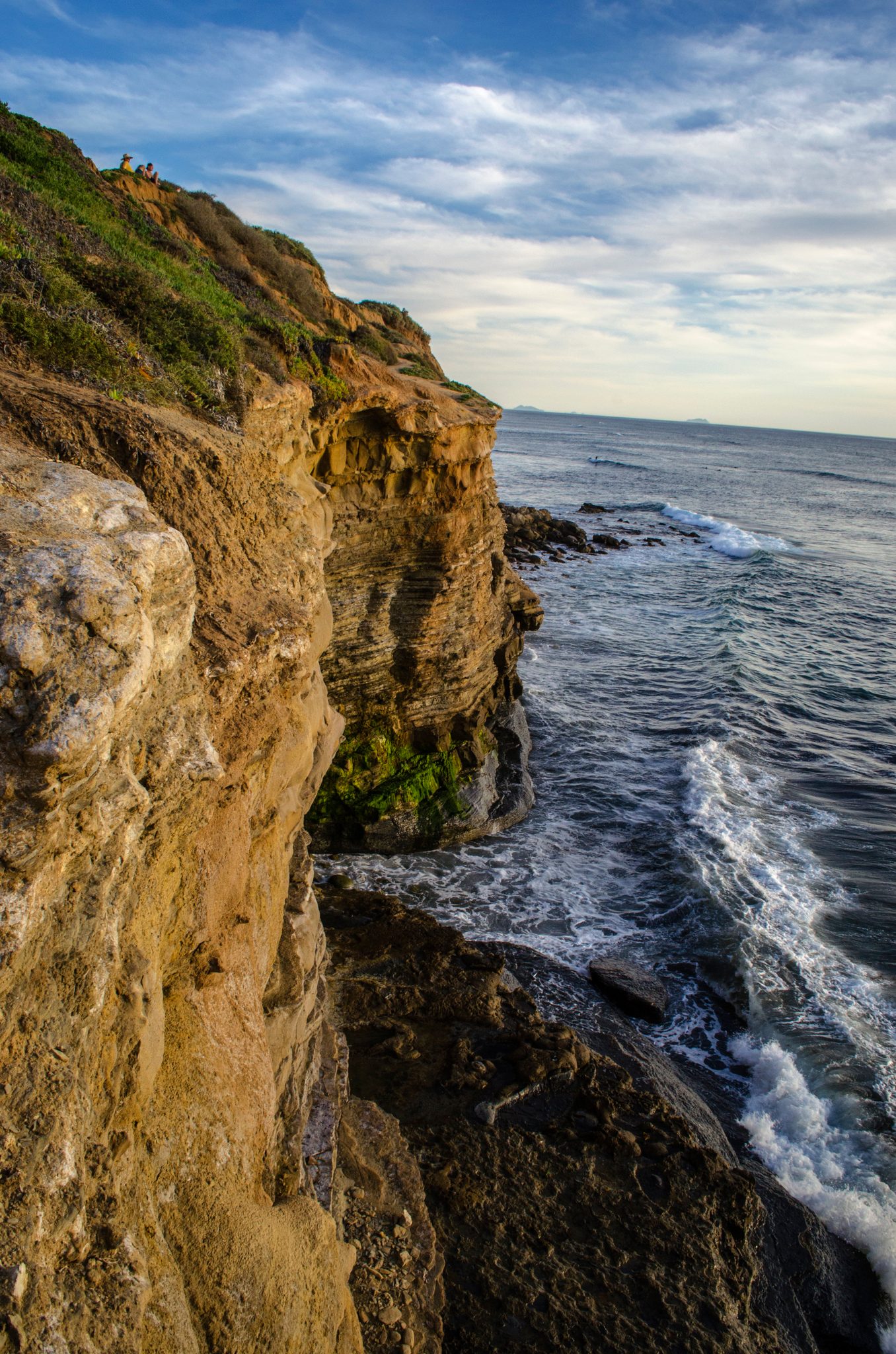 Golden cliffs drop to the surf along the Pacific.