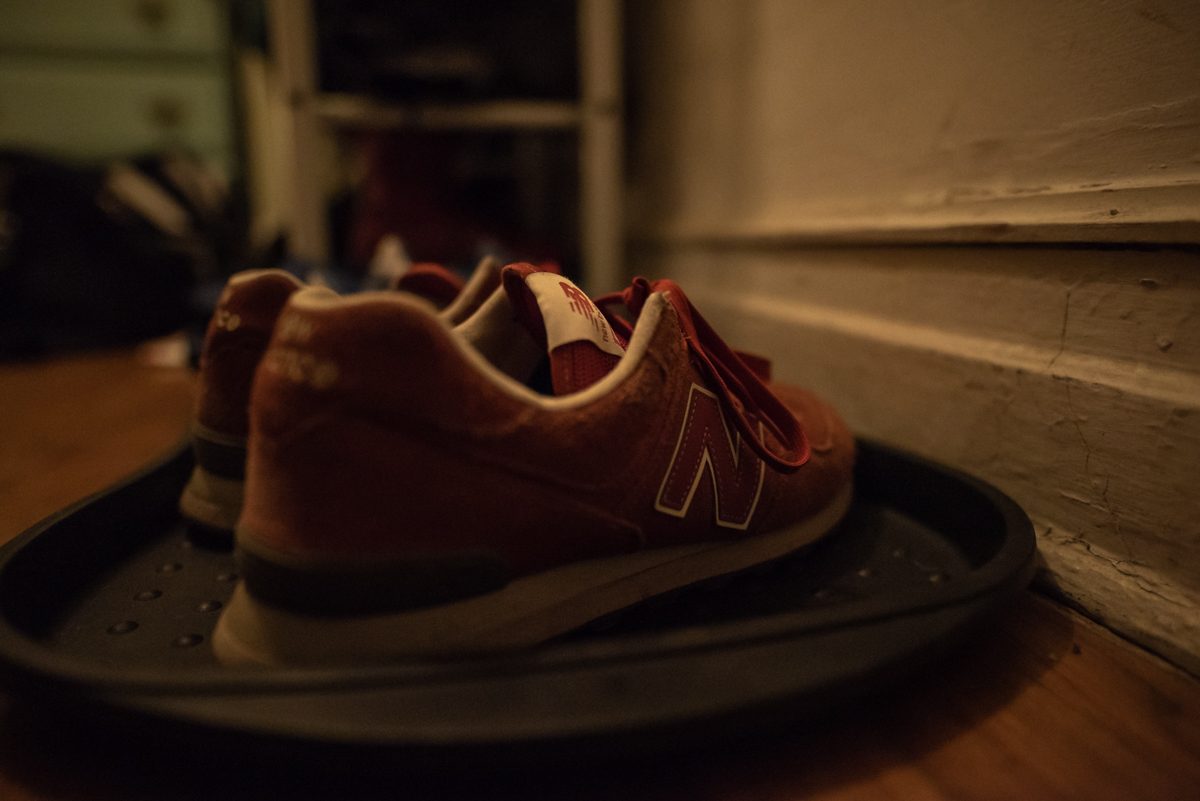 The red sneakers wait on the tray by the door.